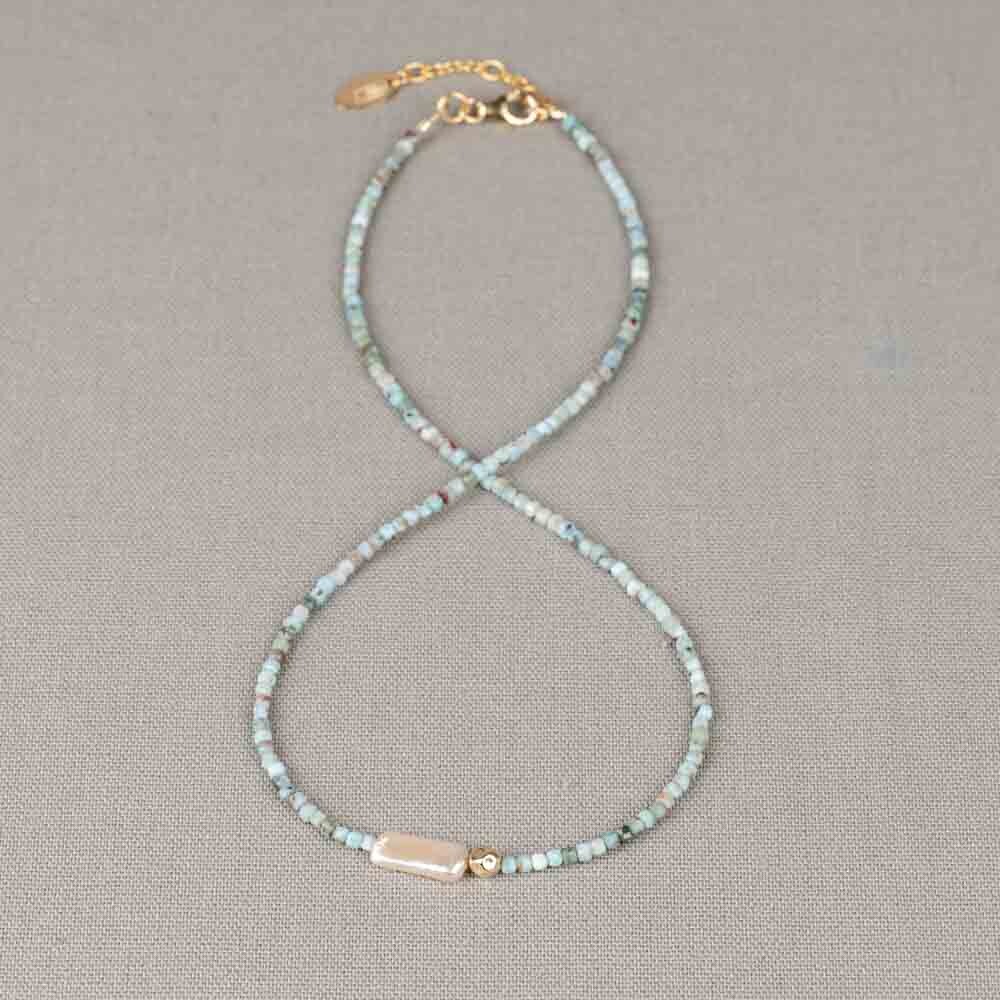 Collier van zachte Larimar in frisse, lichtblauwe tinten, gecombineerd met een elegante Parel als verfijnd middelpunt. Een subtiel Goldfilled balletje voegt een warm en stijlvol accent toe. Combineer met een mooie armband, een paar oorbellen en een ring voor een complete look!