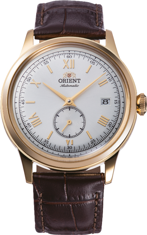 De Orient Bambino Automatic RA-AP0106S30B horloge heeft een goudkleurige roestvrijstalen kast en een bruine leren band met een zilverkleurige wijzerplaat en Romeinse cijfers. Het is een stijlvol automatisch polshorloge met een datumaanduiding en waterbestendig tot 3 ATM. Ideaal voor formele of zakelijke gelegenheden. Draag met formele kleding voor een elegante uitstraling.