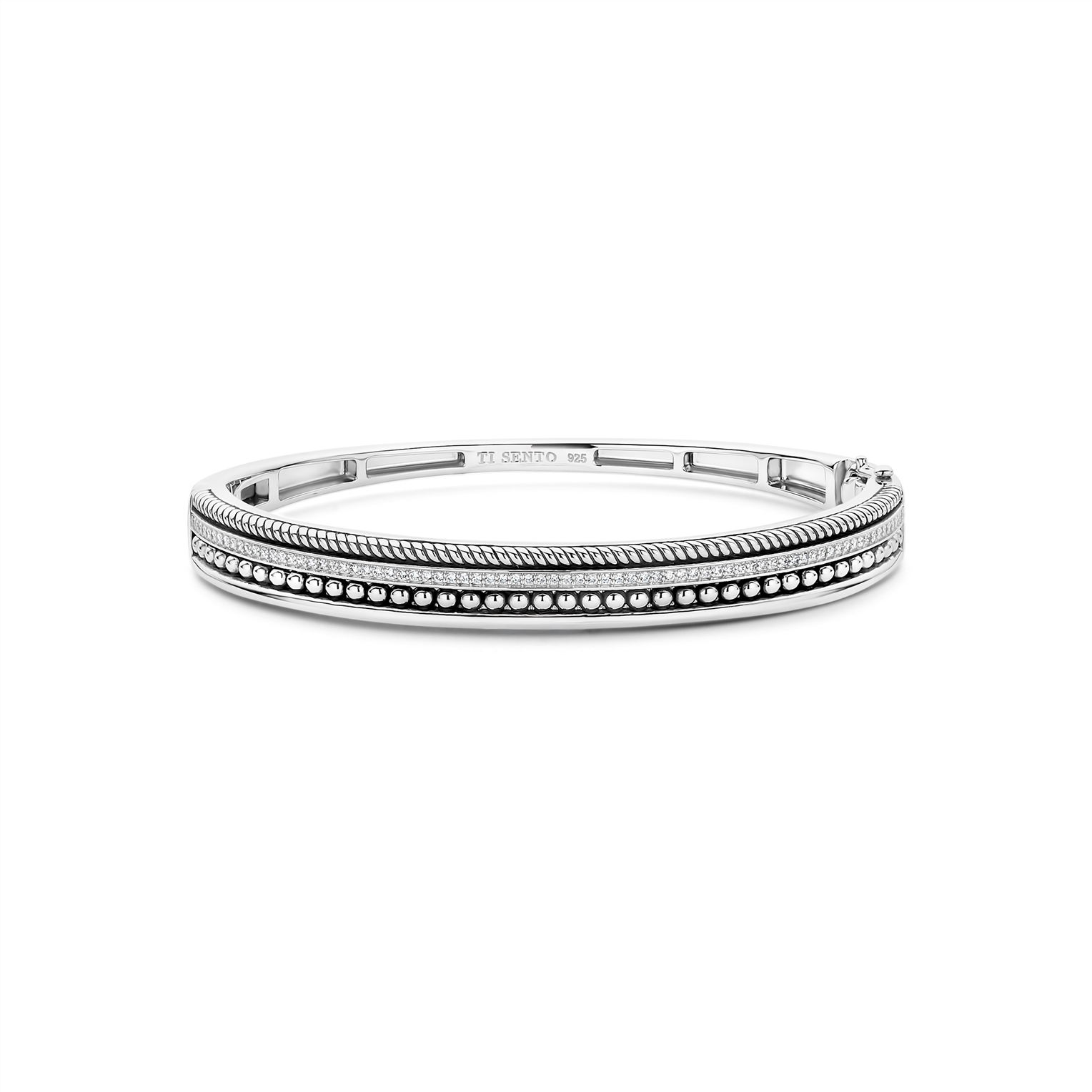 Deze zilveren structured bangle is vervaardigd uit hoogwaardige kwaliteit 925 sterling zilver en heeft een krachtig, architectonisch ontwerp. De brede bangle is opgebouwd uit meerdere structuren, die in ritme en reli&euml;f over de armband lopen. Het samenspel van verschillende texturen geeft diepte en karakter, terwijl het geheel strak en in balans blijft.
