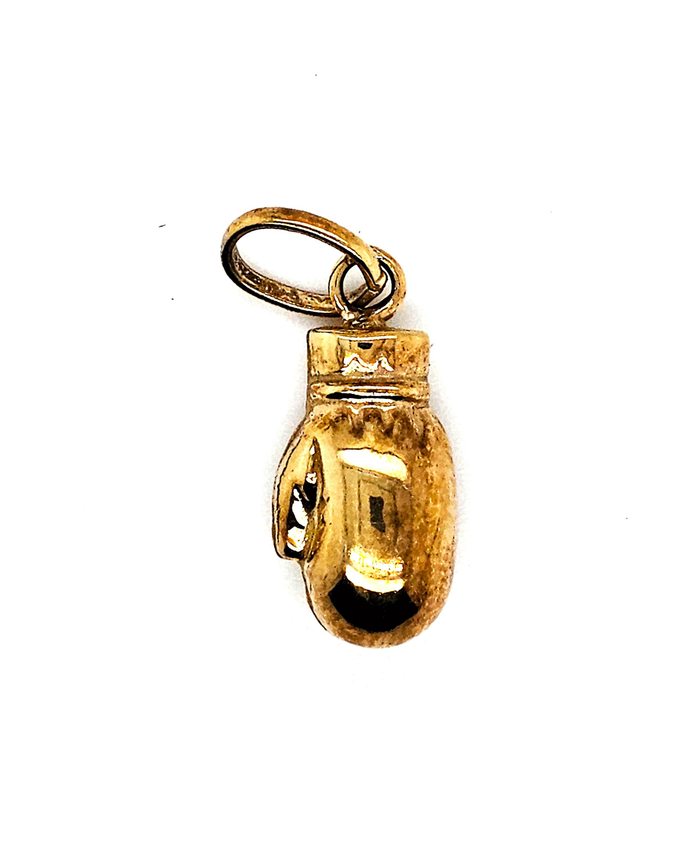 De gouden hanger boxhandschoen met modelnummer GOUDEN HANGER BOXHANDSCHOEN is een elegante hanger, perfect voor sportliefhebbers en boksfans. Gemaakt van hoogwaardig goud, valt hij onder de categorie juweel en type hangers. Draag deze stijlvolle hanger aan een ketting dicht bij je hart voor een persoonlijke en modieuze touch in je dagelijkse outfit.