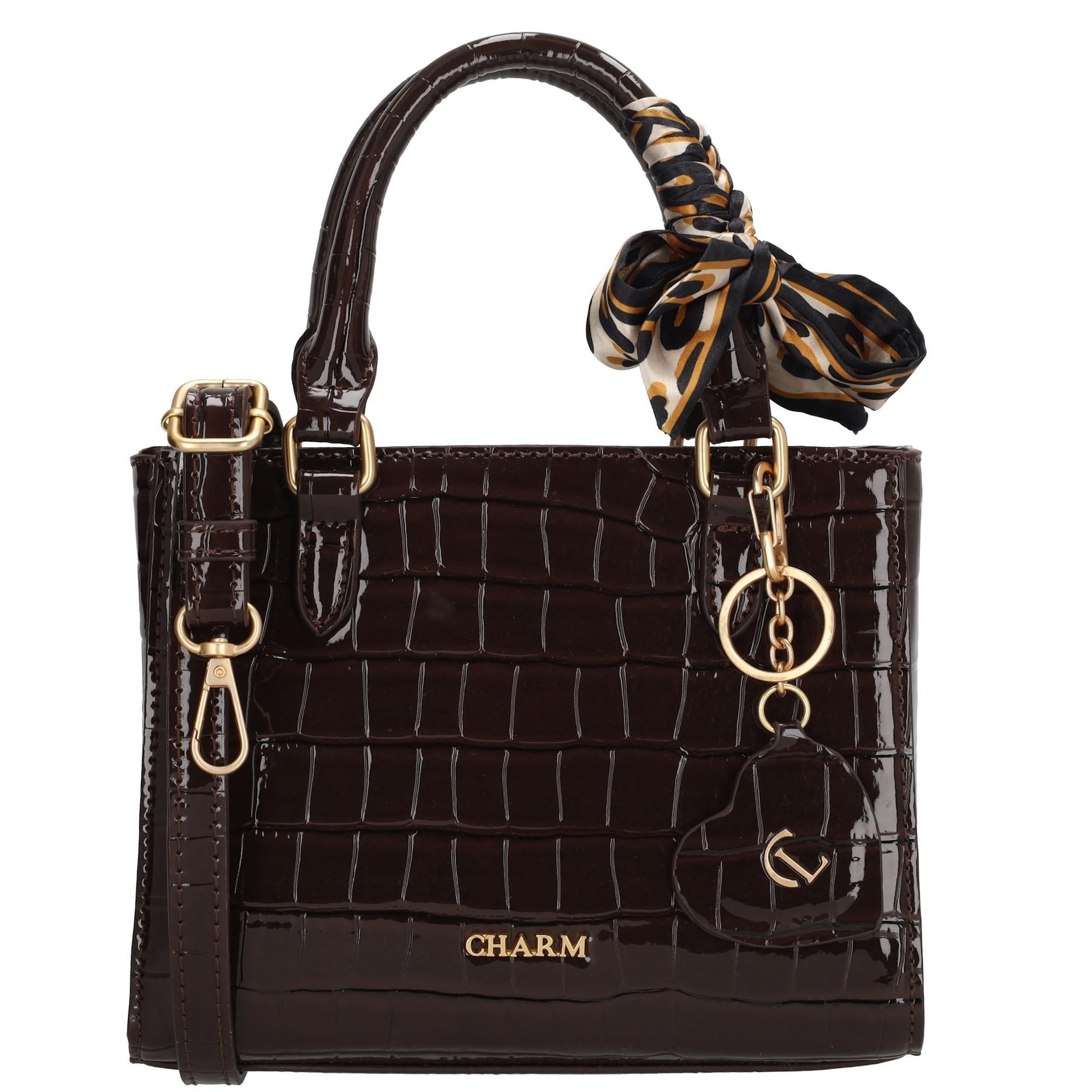 De Charm London Knightsbridge Handtas is een elegante en vrouwelijke tas met een glanzende laklook in croco-reli&euml;f. Dankzij de twee stevige handvatten draag je deze tas comfortabel in de hand of over de arm. Het stijlvolle design maakt de tas perfect voor zowel dagelijks gebruik als speciale gelegenheden.

De tas sluit met een ritssluiting en heeft aan de binnenkant een ritsvak en een telefoonvak voor een overzichtelijke indeling. Je kunt de tas ook als schoudertas dragen dankzij de verstelbare en afneembare schouderband. De goudkleurige details zorgen voor een luxe uitstraling. Als extra detail is de tas afgewerkt met een hartvormige hanger met spiegeltje en een decoratief sjaaltje dat je op verschillende manieren kunt dragen.

Kenmerken:

Laklook met croco-reli&euml;f

Ritssluiting

Twee handvatten

Ritsvak en telefoonvak aan de binnenkant

Verstelbare en afneembare schouderband

Goudkleurige details

Inclusief hartvormige hanger met spiegel

Decoratief sjaaltje, op meerdere manieren te dragen