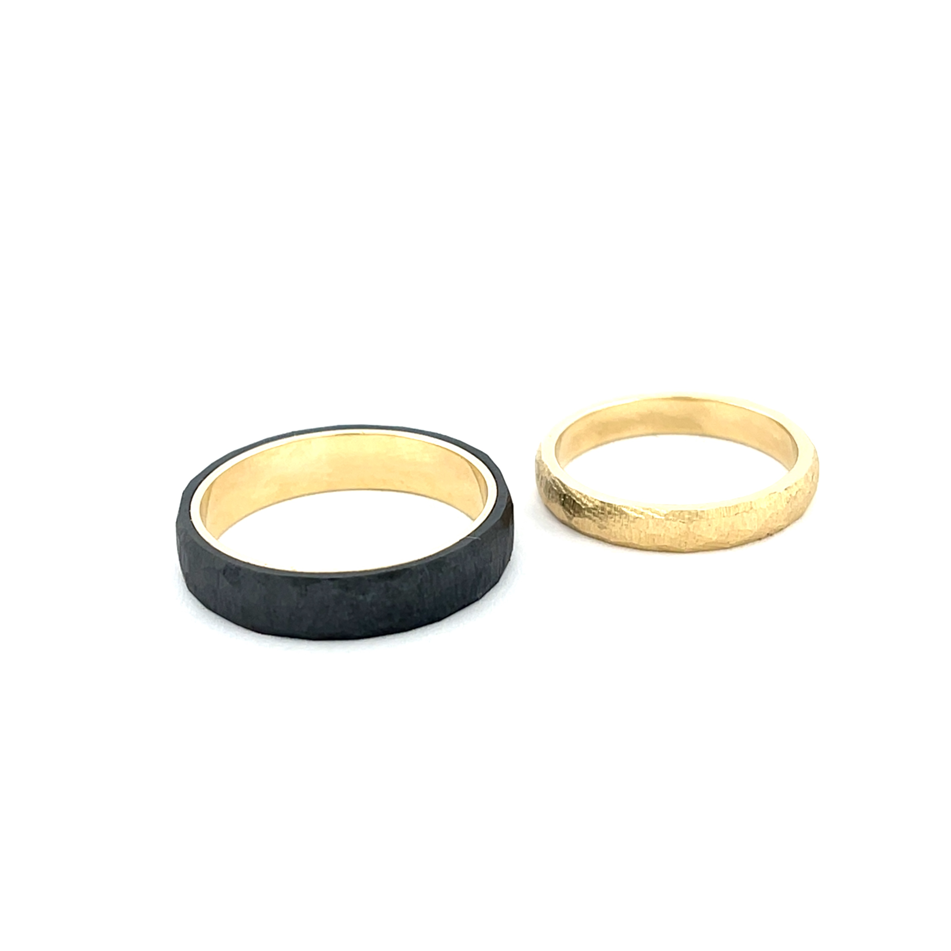Solis is een krachtige samensmelting van contrast en warmte. De diepe, matte zwarte buitenzijde van zirkonium omhult een stralende gouden binnenring, als een kern van licht verborgen in een donker silhouet.

De subtiele textuur aan de buitenkant geeft de ring een stoer en eigentijds karakter, terwijl het gladde goud aan de binnenzijde zorgt voor een warm accent en een comfortabel draaggevoel. Het ontwerp is strak en minimalistisch, maar met een duidelijke uitstraling.

De naam Solis &ndash; Latijn voor zon &ndash; verwijst naar het goud dat van binnenuit lijkt te stralen. Een ring die symbool staat voor kracht, warmte en verbondenheid. Modern in vorm, tijdloos in betekenis.

Maak een afspraak en kom deze sierlijke ring eens passen! Of bestel haar gelijk, dan sturen we deze mooi verpakt naar je toe.