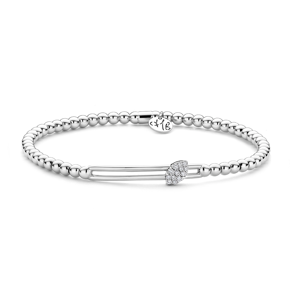 Een verfijnd juweel in 18-karaat witgoud, ontworpen met de kenmerkende bolvormige schakels die zorgen voor een moderne en elegante uitstraling. Dankzij het innovatieve stretch-mechanisme van Hulchi Belluni schuift de armband moeiteloos om de pols en combineert ze luxueuze uitstraling met uitzonderlijk draagcomfort.