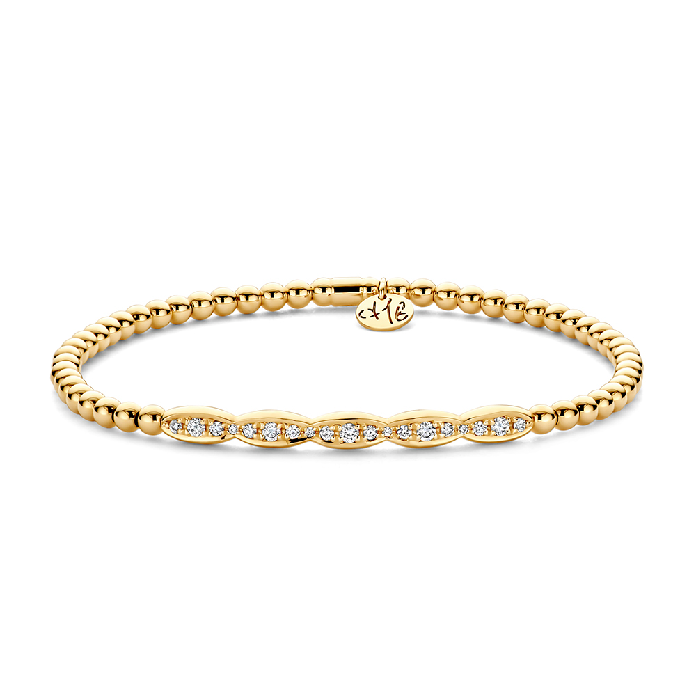 Een elegante armband in 18-karaat geelgoud, opgebouwd uit verfijnde goudbolletjes met een centraal diamantmotief dat subtiel schittert bij elke beweging. Het kenmerkende stretchontwerp zorgt ervoor dat de armband soepel over de hand schuift en comfortabel rond de pols zit, perfect voor dagelijks luxueus dragen.