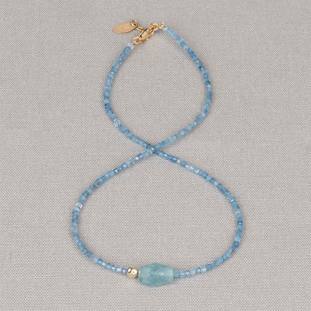 Dit elegante collier is gemaakt van Aquamarijn , die het sieraad een frisse en zachte blauwe uitstraling geven. In het midden vormt een ruwe Aquamarijn steen het natuurlijke en speelse middelpunt van het ontwerp. Het Goldfilled bolletje zorgt voor een subtiel warm accent en een mooi contrast met de koele tinten van de edelsteen. Het resultaat is een verfijnd en licht collier met een natuurlijke, elegante uitstraling dat prachtig alleen te dragen is of te combineren met andere sieraden.