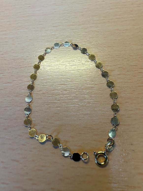 De armband is verguld met kleine ronde plaatjes