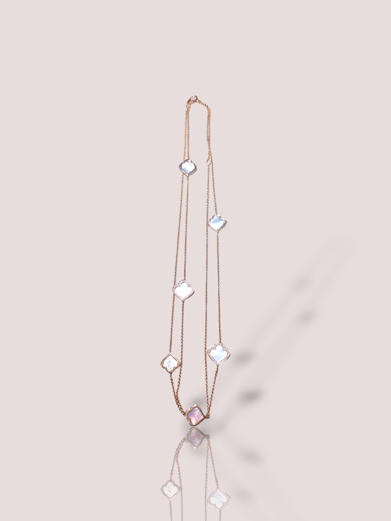 Dit betoverende Vintage 18k ros&eacute;gouden collier combineert elegant parelmoer met fonkelende diamanten. Als een schitterend sieraad binnen de categorie juwelen, voegt deze ketting tijdloze klasse toe aan elke outfit. Draag het bij formele gelegenheden of om een alledaagse look te verfraaien. Een must-have voor elke liefhebber van verfijning en stijl. Het collier is 90 cm lang en heeft 6 prachtige ornamenten met parelmoer en diamant.