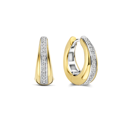 De Layered Zirkonia Hoops zijn vervaardigd uit hoogwaardige kwaliteit 925 sterling zilver en afgewerkt met een goudkleurigee goudkleurige finish. Deze oorringen lopen subtiel breder uit aan de onderzijde, wat zorgt voor een gelaagd en krachtig silhouet. In het midden van de hoops loopt een verfijnde rij zirkonia steentjes, die zorgvuldig zijn gezet en bij elke beweging het licht vangen. De diameter van deze hoops is 16 mm, waardoor ze mooi in balans zijn tussen elegant en uitgesproken.

Het gelaagde ontwerp geeft deze goudkleurige zirkonia oorbellen een moderne, luxe uitstraling met extra diepte. De combinatie van het strakke goudkleurigee oppervlak en de fonkelende zirkonia&rsquo;s maakt deze hoops tot echte statement oorbellen, terwijl het formaat ze ook zeer geschikt maakt om elke dag te dragen. Perfect om solo te dragen of te combineren met andere goudkleurige of zirkonia sieraden. 78049ZY Circles & Cross-over oorbellen