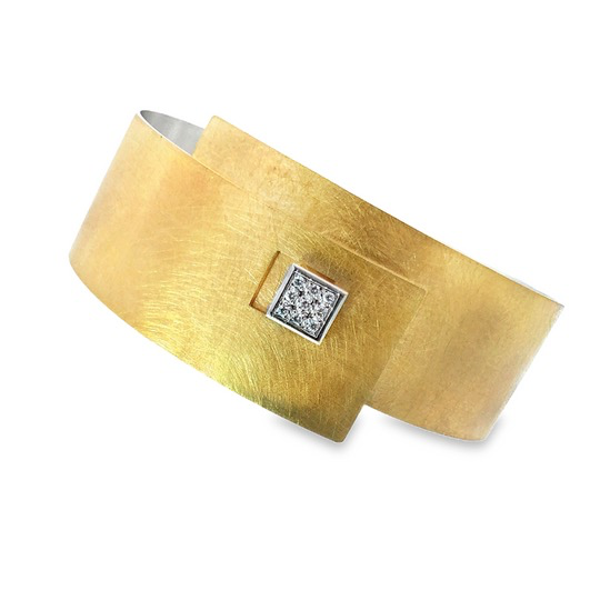 Der Armreif besticht durch seine edle Kombination aus Silber und Gelbgold 900, verziert mit einem Schlie&szlig;knopf und insgesamt 0,09 ct Brillanten. Als Sklavenarmband eignet er sich ideal f&uuml;r elegante Anl&auml;sse. Tragen Sie es am besten allein, um seine Raffinesse zu betonen, oder kombiniert mit weiteren dezenten Schmuckst&uuml;cken f&uuml;r einen stilvollen Auftritt.