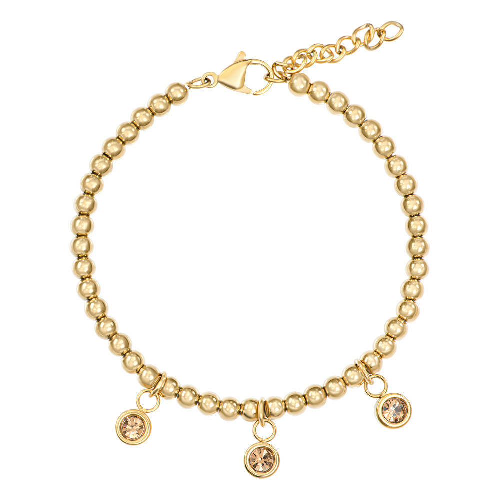 De iXXXi Armband &lsquo;Dot Topaz&rsquo; is gemaakt van stainless steel en bestaat uit goudkleurige kralen. In het midden van de armband zijn drie cups ingelegd met zirconia&rsquo;s in de kleur topaz, wat de armband een sprankelende en verfijnde uitstraling geeft.