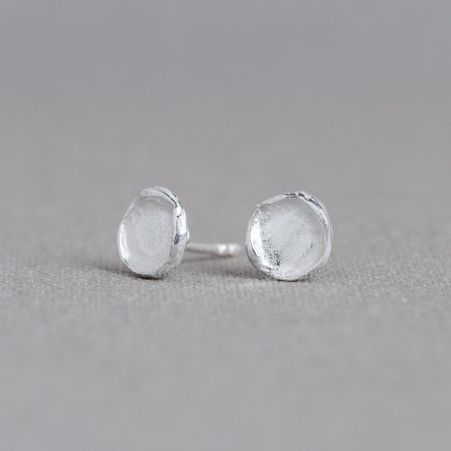 Deze ronde oorstekers zijn gemaakt van 925 sterling zilver en hebben een zachte, minimalistische vorm met een subtiele structuur in het oppervlak. De lichte glans en het licht onregelmatige karakter geven de oorbellen een pure en tijdloze uitstraling. Dit ontwerp behoort al bijna vanaf het begin tot de collectie van J&eacute;h Jewels en is uitgegroeid tot een herkenbare klassieker. De oorbellen zijn ook verkrijgbaar in verguld en in geoxideerd zilver.