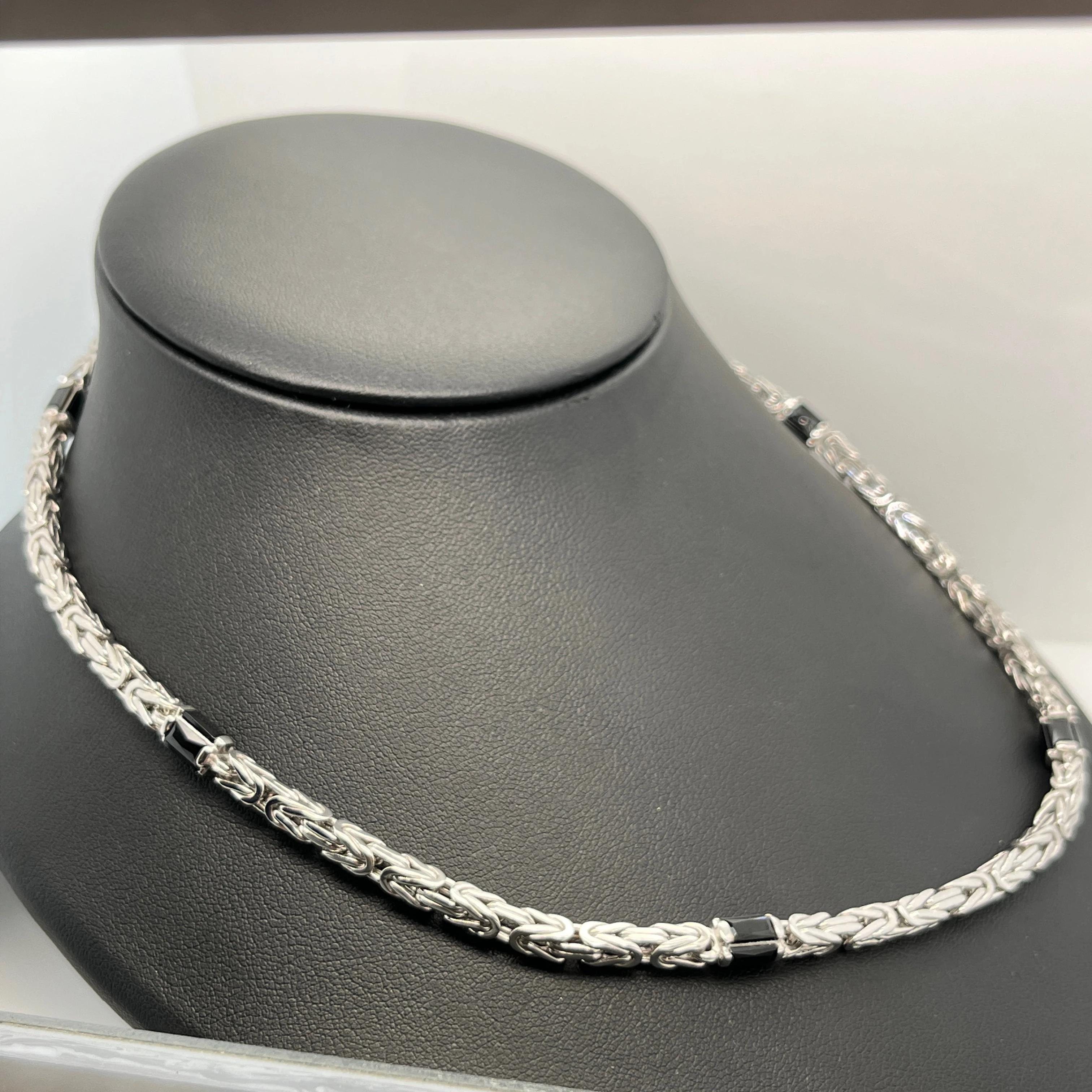 Zilveren collier in koningsschakel, met als tussen schakel een zwarte facet geslepen zirkonia steen. 
Schakel breedte is 4mm
