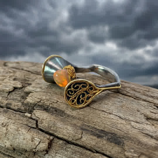 Der Smartcurvring Au/Ag Feueropal besticht durch 18-kar&auml;tiges Gold, ein Gewicht von 5 Gramm und einen atemberaubenden 3,54 ct Feueropal. Ideal f&uuml;r feierliche Anl&auml;sse oder als stilvolles Accessoire im Alltag. Tragen Sie ihn solo oder in Kombination mit anderen Ringen f&uuml;r einen eleganten Look. Perfekt passend in Gr&ouml;&szlig;e 56.