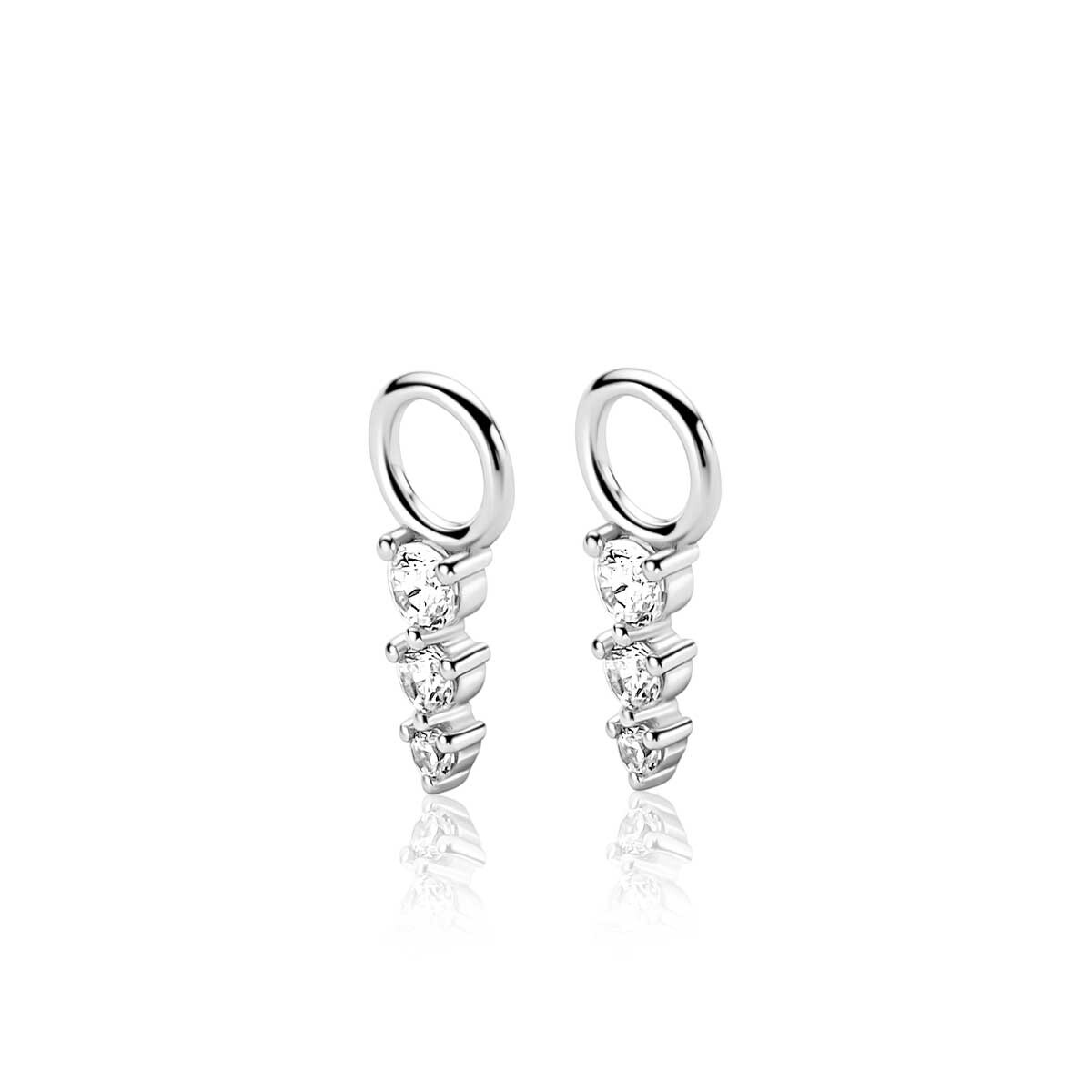 ZINZI zilveren oorbedels met drie onder elkaar geplaatste witte zirkonia&rsquo;s in verschillende groottes en verfijnde chatonzetting (13mm). De verticale lijn van sprankelende zirkonia&rsquo;s geeft deze oorbedel een tijdloze uitstraling. Perfect te combineren met ZINZI oorringen voor een persoonlijke en stijlvolle look. Vervaardigd van eerste gehalte zilver (925) en voorzien van een extra rodiumlaag voor een langdurige glans.