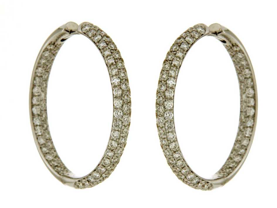 Stijlvolle ronde oorringen in witgoud stralen een koele, moderne elegantie uit met hun heldere glans. Midi gezet met diamanten rondom en binnenin zorgen ze voor een verfijnde, gelijkmatige schittering die het ontwerp een luxueus en tijdloos karakter geeft.