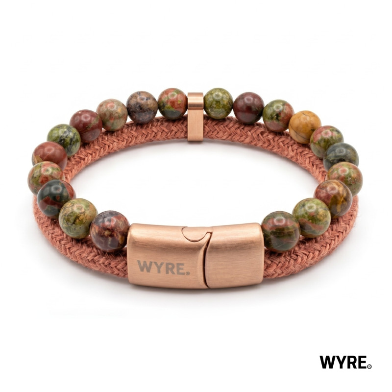 Ontdek de perfecte balans tussen robuuste natuur en verfijnde elegantie met de WYRE Sienna armband. Een stijlvolle toevoeging aan iedere outfit, of je nu op avontuur gaat of geniet van een ontspannen middag op het terras. De WYRE Sienna combineert warme aardetinten met een luxueuze afwerking. De armband is zorgvuldig ontworpen met prachtige, veelkleurige natuurstenen kralen in groene, olijfkleurige en de kenmerkende roestbruine sienna-nuances. Deze stenen worden perfect aangevuld door het robuuste, jute koord in een bijpassende koper/ros&eacute; tint. Het resultaat is een uniek sieraad dat door zijn dubbele laag zowel stoer als chic oogt.

bannerwyre.jpg
Uniek Karakter: Elke kraal is gemaakt van authentiek natuursteen, waardoor geen enkele armband exact hetzelfde is. Je draagt altijd een uniek patroon met je mee.

Ultiem Gebruiksgemak: De armband is voorzien van een sterke ros&eacute;kleurige magneetsluiting met een subtiel gegraveerd WYRE-logo. Deze sluiting is niet alleen een prachtige eyecatcher, maar zorgt er ook voor dat je de armband moeiteloos en veilig sluit.

Oersterk Ontwerp: Geen zorgen over knappende elastiekjes of brekende sieraden. De kralen zijn stevig geregen aan een sterke metalen interne draad, waardoor de armband uitzonderlijk duurzaam en vrijwel onbreekbaar is.

Veelzijdig: Of je hem nu draagt bij een casual trui, een nette linnen blazer of je outdoor-outfit, het veelzijdige design past zich moeiteloos aan jouw stijl aan.

✓ Materiaal: Stainless steel (RVS), edelstenen.
✓ Afmeting: 14x8 mm
✓ Kleur: rood en rosegoud
✓ Sluiting: Stevige, magnetische schuifsluiting.
✓ Handmade: Handgemaakt in Nederland.
✓ Luxe travel case: Inclusief metalen luxe WYRE travel/cadeau case.