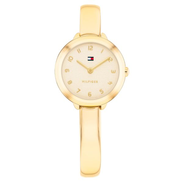 Dit Tommy Hilfiger dameshorloge uit de Demi Bangle serie combineert het elegante karakter van een armband met de uitstraling van een stijlvol uurwerk. De ronde horlogekast van 26 mm is uitgevoerd in goudkleurig staal en loopt vloeiend over in de kenmerkende bangle band, wat zorgt voor een verfijnd en modern silhouet. De goudkleurige wijzerplaat met subtiele glans, fijne wijzers en het herkenbare Tommy Hilfiger logo geeft dit model een luxe en vrouwelijke uitstraling. De stevige stalen bangle band sluit mooi om de pols met een praktische druksluiting en is bovendien eenvoudig op maat te maken voor een comfortabele pasvorm. Het horloge beschikt over sterk mineraalglas en wordt aangedreven door een betrouwbaar quartz uurwerk. Met een waterdichtheid van 3ATM is het bestand tegen regen en spatwater.