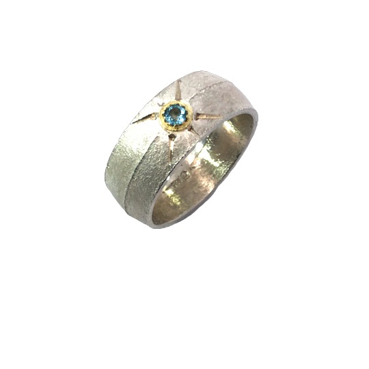 Der Ring Silber 925, Sandguss 10mm; oxyd., G.750, mit Blauem Topas  besticht durch sein elegantes Design. Er geh&ouml;rt zur Kategorie Schmuck und hat die Gr&ouml;&szlig;e 61. Tragen Sie diesen Ring am besten als auff&auml;lliges Schmuckst&uuml;ck zu festlichen Anl&auml;ssen oder als t&auml;gliches Highlight zu Ihrem Lieblingsoutfit.