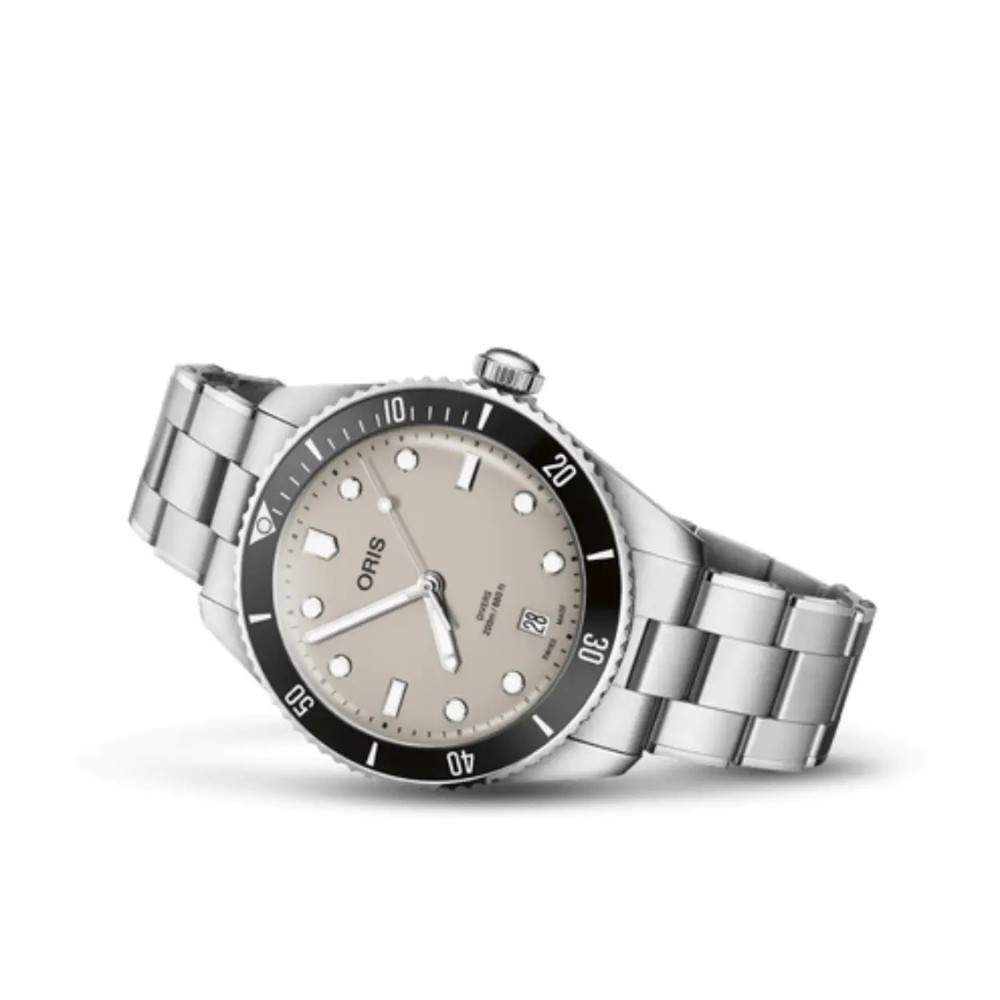Geheel in de geest van de eerste Oris duikhorloges uit de jaren &rsquo;60, beter bekend als de &ldquo;Sixty-Five&rdquo;, heeft Oris de nieuwe Divers Date collectie gelanceerd. Dit horloge is uitgevoerd met een beige wijzerplaat en komt zowel met een metalen- als zwart rubberen band.
De design- en prestatie-upgrades van de Divers Date omvatten een keramische lunette en waterbestendigheid tot 20 bar (200 meter). Het wordt aangestuurd door een automatisch uurwerk van Zwitserse makelij en wordt geleverd met een snel verwisselbare metalen band en een zwarte rubberen band.