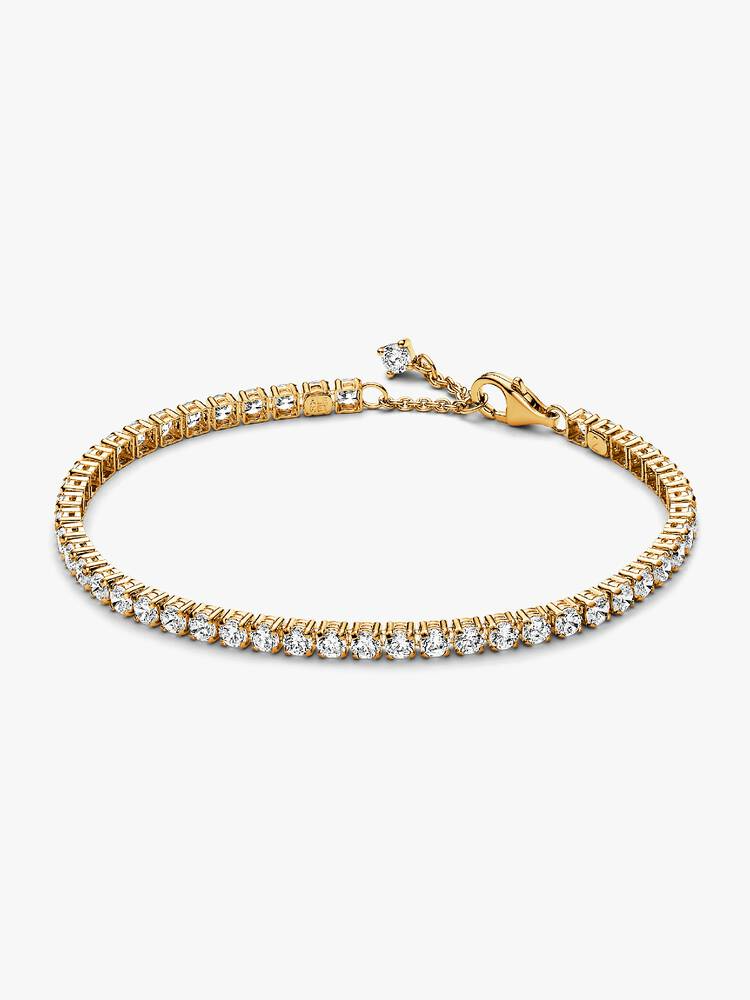 Kies een moderne uitvoering van een klassieke stijl met de Sprankelende Tennisarmband. Deze vergulde armband glinstert met 48 ronde stenen in klauwzetting. De verstelbare en dynamische tennisarmband met zirkonia is afgewerkt met een sprankelende steen die naast de sluiting hangt voor de perfecte finishing touch. Deze armband met iets grotere stenen dan onze andere tennisarmbanden is perfect om een fris statement te maken als je hem stapelt met andere armbanden in verschillende tinten en stijlen.