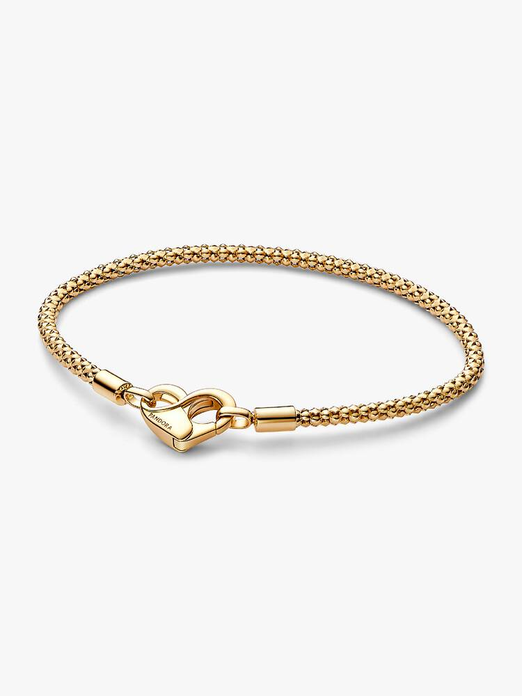 Update je verzameling met onze nieuwe studs-schakelarmband van Pandora Moments, gemaakt van een unieke metaalmix, verguld. Deze met de hand afgewerkte sterlingzilveren armband bestaat uit een flexibele ketting met reli&euml;f en een hartvormige sluiting die met een ge&iuml;ntegreerd oneindigheidsteken geopend kan worden. Let op: deze schakelarmband heeft geen schroefdraad (verhoogde bedelverdelers). Aan de armband kunnen maximaal 14-18 bedels of hangende bedels worden bevestigd. Aan de sluiting kunnen geen bedels worden bevestigd. We raden je aan om bedels met siliconen inzetten te gebruiken of veiligheidskettingen toe te voegen om je bedels niet te verliezen.