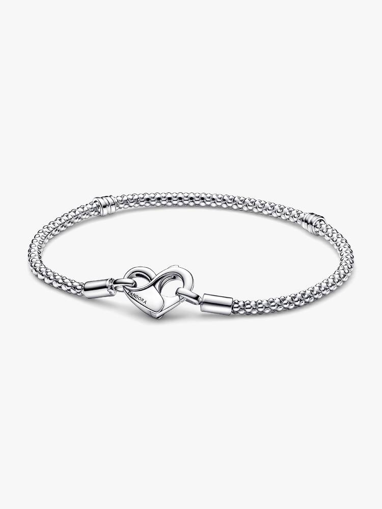 Update je collectie met onze nieuwe Pandora Moments-studded schakelarmband. Deze hand-finished sterlingzilveren armband bestaat uit een flexibele, bewerkte ketting en een hartvormige sluiting gedetailleerd met het oneindigheidsteken dat geopend kan worden. Let op: kan worden gestyled met 14 tot 18 bedels, hangende bedels of hangers tussen de drie secties gedeeld door de schroefdraden.
