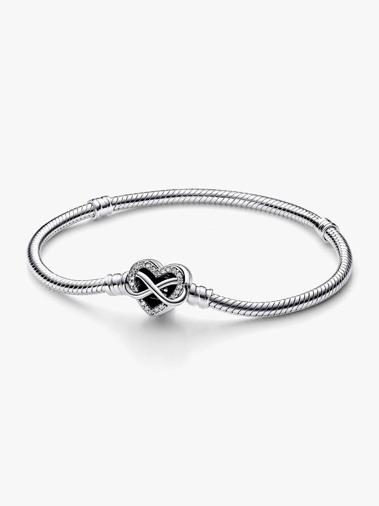 De Pandora Moments Sprankelende Snake Chain Armband met Hartsluiting vertegenwoordigt de eeuwige liefde die familie met elkaar verbindt en is een betekenisvol geschenk voor degenen die voor jou het belangrijkst zijn. De opengewerkte hartsluiting is bezet met stenen langs de rand van het motief en een asymmetrisch oneindigheidssymbool dat om het hart draait. De achterkant van de sluiting is gegraveerd met de boodschap, 'Family forever and Always'. De armband heeft twee schroefdraden (verhoogde bedelverdelers) die hem in drie delen verdelen. Style met 16-18 van je favoriete bedels of hangende bedels als symbool voor de mensen van wie je houdt, of geef cadeau aan iemand om wie je geeft.