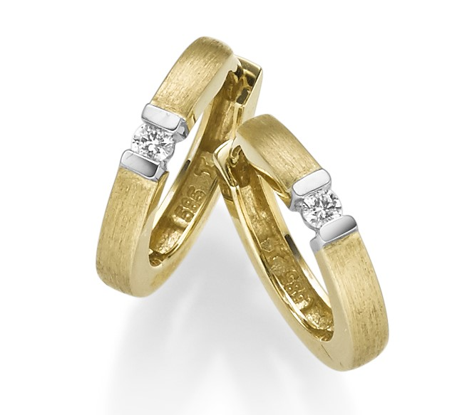 een paar 14 krt geelgouden oorringen met een witgouden zetting waarin een diamant briljant geslepen 0.03 crt G SI per stuk.