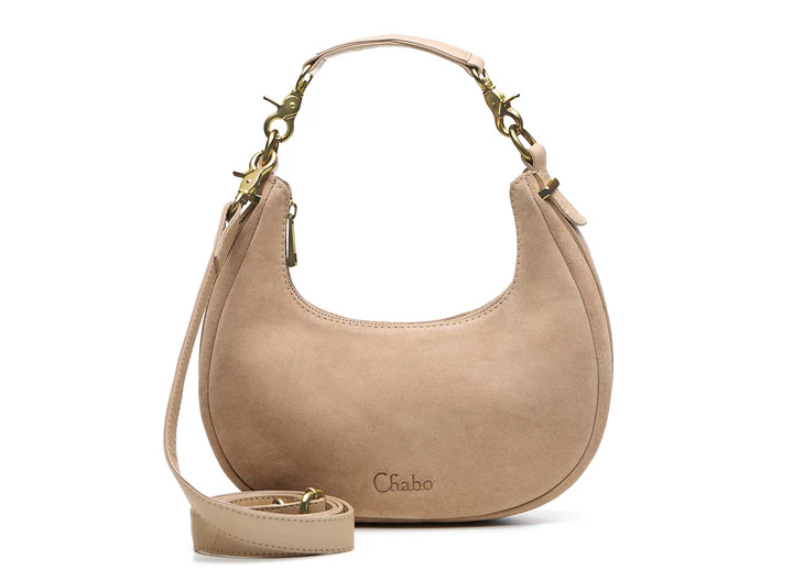 Ontdek de leren Sydney Shoulderbag

Afmeting 26 x 14 x 7 cm

Een fashionable ronde suede tas met leren bies, afneembaar leren handvat en extra lange crossover band. Praktisch ingedeeld met insteekvak en ritsvak.

De Sydney Shoulderbag is een stijlvolle en fashionable tas die iedere outfit een trendy uitstraling geeft. Het ronde model in zacht leer zorgt voor een elegante en moderne look, terwijl de leren bies rondom de tas zorgt voor een luxe afwerking.

De tas is voorzien van een leren afneembaar handvat, waardoor je hem stijlvol als schoudertas kunt dragen. Liever handsfree onderweg? Verwissel het korte handvat eenvoudig voor de extra lange crossover band en draag de tas comfortabel crossbody.
Ook aan de binnenkant is de Sydney Shoulderbag praktisch ingedeeld.

De tas beschikt over een handig insteekvak aan de ene kant voor kleinere essentials zoals je telefoon of lipgloss. Aan de andere kant bevindt zich een afsluitbaar ritsvak voor het veilig opbergen van waardevolle spullen.

Dankzij het compacte maar ruime ontwerp is deze  schoudertas perfect voor dagelijks gebruik, een avondje uit of een dag shoppen.

