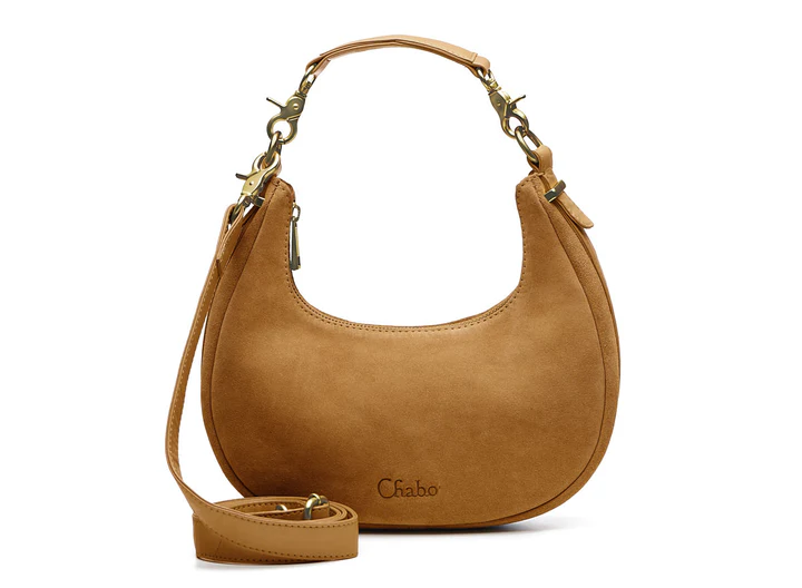 Ontdek de leren Sydney Shoulderbag

Afmeting 26 x 14 x 7 cm

Een fashionable ronde suede tas met leren bies, afneembaar leren handvat en extra lange crossover band. Praktisch ingedeeld met insteekvak en ritsvak.

De Sydney Shoulderbag is een stijlvolle en fashionable tas die iedere outfit een trendy uitstraling geeft. Het ronde model in zacht leer zorgt voor een elegante en moderne look, terwijl de leren bies rondom de tas zorgt voor een luxe afwerking.

De tas is voorzien van een leren afneembaar handvat, waardoor je hem stijlvol als schoudertas kunt dragen. Liever handsfree onderweg? Verwissel het korte handvat eenvoudig voor de extra lange crossover band en draag de tas comfortabel crossbody.
Ook aan de binnenkant is de Sydney Shoulderbag praktisch ingedeeld.

De tas beschikt over een handig insteekvak aan de ene kant voor kleinere essentials zoals je telefoon of lipgloss. Aan de andere kant bevindt zich een afsluitbaar ritsvak voor het veilig opbergen van waardevolle spullen.

Dankzij het compacte maar ruime ontwerp is deze  schoudertas perfect voor dagelijks gebruik, een avondje uit of een dag shoppen.

