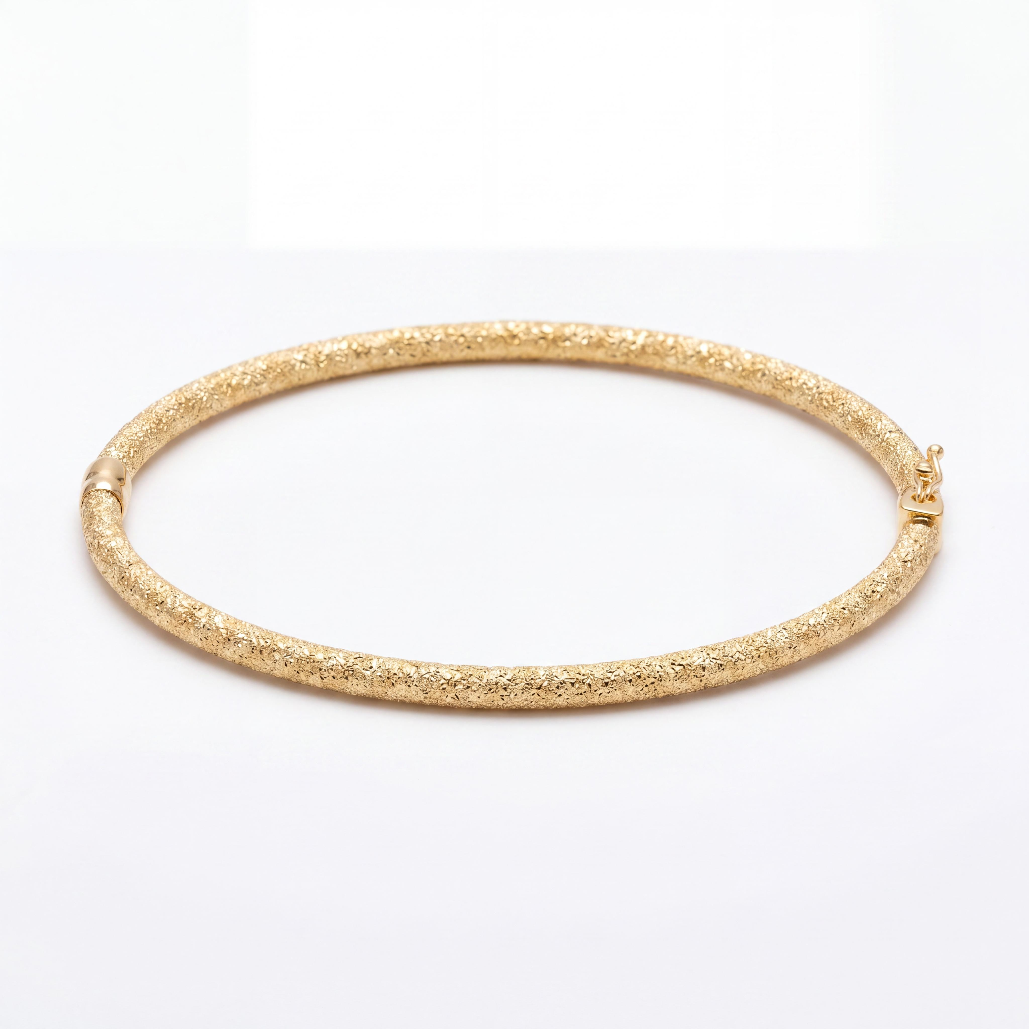 Laat uzelf betoveren door de unieke schittering van puur vakmanschap. Deze exclusieve handgemaakte 14 karaat gouden slavenarmband (bangle) van Juwelier Rijk Amsterdam is een absolute blikvanger. Wat deze armband zo bijzonder maakt, is de gediamanteerde afwerking. Deze speciale bewerking zorgt voor een fonkelend 'ijs-effect' dat het licht bij elke beweging op een spectaculaire manier reflecteert.

Traditioneel handgemaakt & verfijnd buisontwerp
De armband is met liefde en uiterste precisie met de hand vervaardigd in een klassieke ronde buisvorm. Met een subtiele en elegante breedte van 3 mm valt de armband verfijnd om de pols. Dankzij het gewicht van circa 3.5 gram is de armband heerlijk licht om te dragen, maar door de sterke buisconstructie toch stevig genoeg voor dagelijks gebruik.

De subtiele glanzende details bij het scharnier en de sluiting vormen een prachtig, rustig contrast met het intens sprankelende gediamanteerde oppervlak. Een uniek, handgemaakt sieraad dat klasse en modern design naadloos combineert.