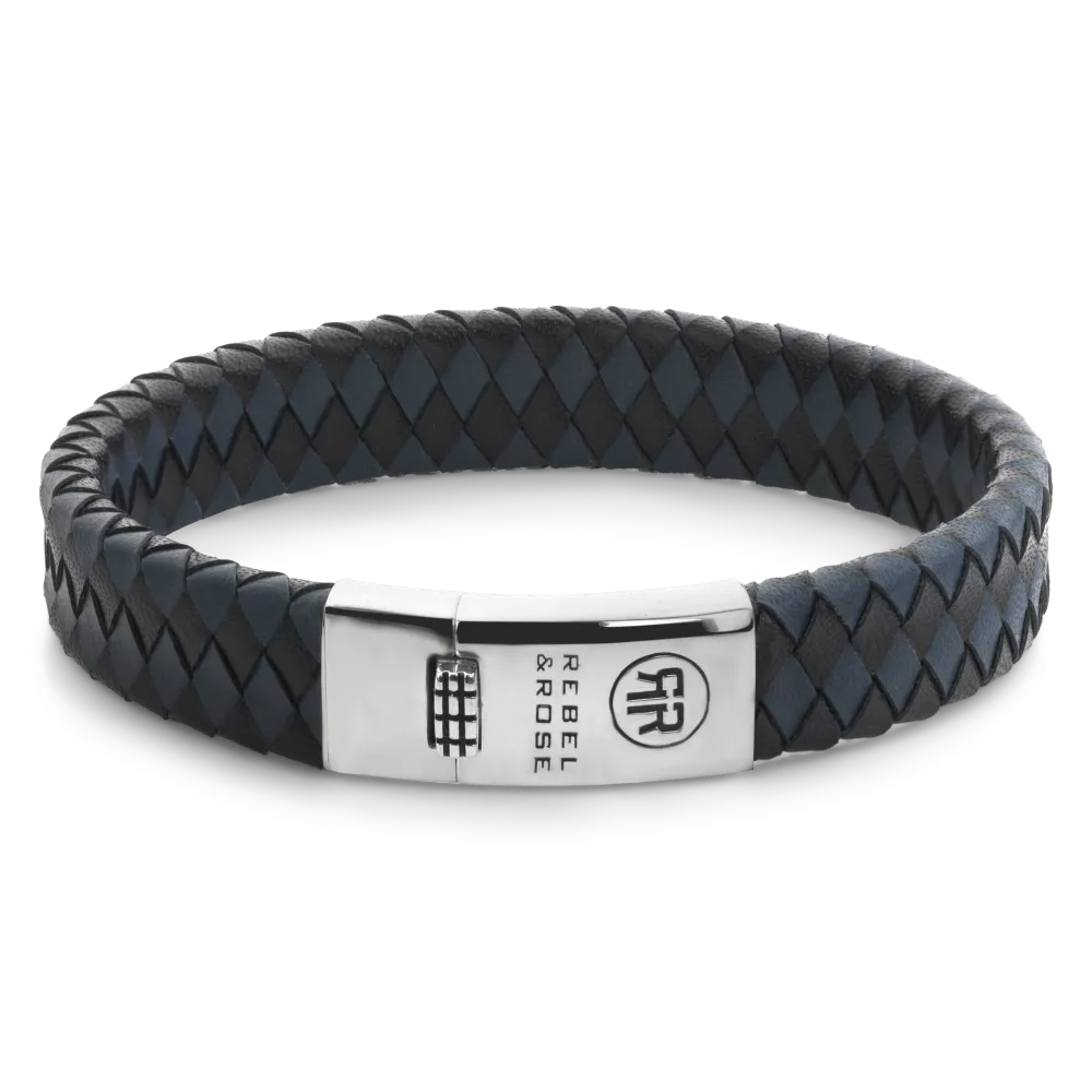 De Braided Flat 925 armband van Rebel and Rose is 12 mm breed en handgemaakt, met volledig zilveren sluiting. Het zwarte en blauwe leer is met veel zorg en vakmanschap gelooid door de ambachtslieden van Rebel and Rose. Prachtig rundleer dat mooier en soepeler wordt naarmate je het langer draagt. Ze doen het perfect in combinatie met onze Sterling Zilveren armbanden, ringen en kralen armbanden.