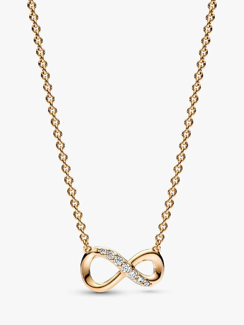 Vier je liefde tot in de oneindigheid en verder met deze sprankelende oneindigheid halsketting. Dit met verguld sieraad met een vast oneindigheidssymbool symboliseert de kracht van onbreekbare banden en herinnert je aan de liefde die je deelt met hen die voor jou het belangrijkst zijn. Het symbool is bezet met stenen langs de bovenste lijn van het motief en een schuifsluiting zodat je de lengte van je collier kunt aanpassen. Draag als een manier om je waardering voor een geliefde te tonen of geef cadeau aan iemand die je na aan het hart ligt.