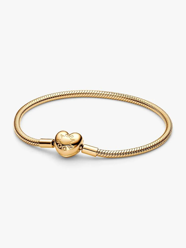 Laat je verhaal stralen met de Pandora Moments Hartsluiting Snake Chain Armband. Onze iconische snake chain-armband is verguld met 14k goud en heeft een gepolijste hartvormige sluiting. De sluiting is aan de ene kant voorzien van een gegraveerd Pandora-logo en aan de andere kant van het Pandora Crown O-logo. Style deze snake chain-armband met maximaal 16 tot 18 bedels voor een unieke look die helemaal bij jou past.
