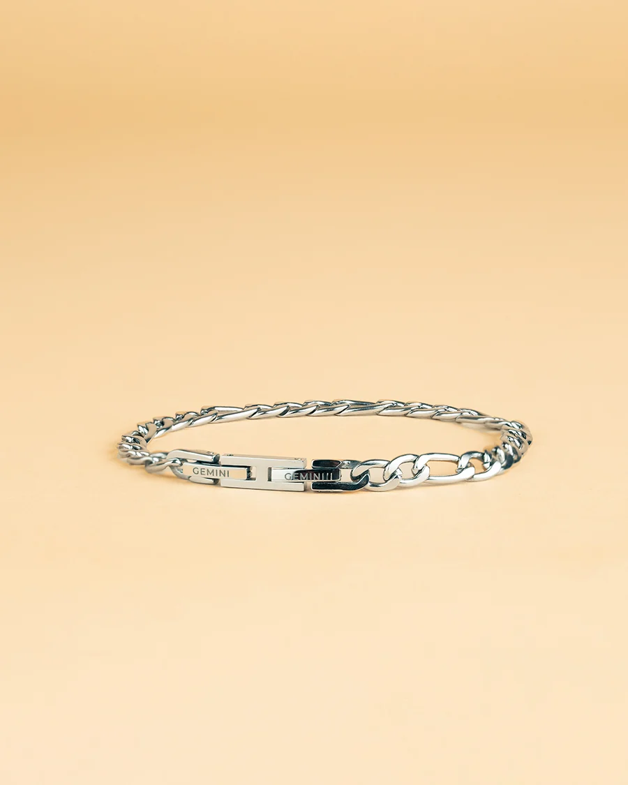 De armband FORTIS SILVER, zilverkleurig met figaro schakelpatroon .. Deze stijlvolle armband in maat M-L straalt elegantie uit. Draag hem solo voor een minimalistische look of combineer met andere zilveren sieraden voor een trendy gelaagde stijl. Perfect voor zowel dagelijks gebruik als speciale gelegenheden.