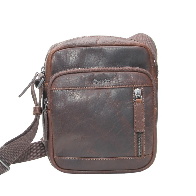 Esquire Buffel Lederen Crossbody Tas &ndash; Compact, Stijlvol en Praktisch
De Esquire buffel lederen crossbody tas is de ideale tas voor dagelijks gebruik. Gemaakt van hoogwaardig buffelleer combineert deze compacte schoudertas een stijlvolle uitstraling met praktische opbergruimte. Het duurzame leer krijgt na verloop van tijd een prachtig, karakteristiek patina.

Het ruime hoofdvak is afsluitbaar met een stevige ritssluiting en beschikt aan de binnenzijde over een ritsvak en een steekvak voor je telefoon, zodat je waardevolle spullen overzichtelijk kunt opbergen. Aan de voorzijde bevindt zich een extra vak met ritssluiting, afgewerkt met de kenmerkende gestreepte voering, ideaal voor het opbergen van kleine essentials die je snel bij de hand wilt hebben. Ook aan de achterzijde is een handig ritsvak aanwezig voor bijvoorbeeld sleutels, pasjes of reisdocumenten.

De verstelbare schouderriem zorgt ervoor dat je de tas comfortabel op de gewenste lengte kunt dragen, zowel over de schouder als crossbody.

Afmetingen
Hoogte: 23 cm
Breedte: 20 cm
Diepte: 8 cm
Kenmerken
Gemaakt van hoogwaardig buffelleer
Hoofdvak met ritssluiting
Binnenvak met ritssluiting
Steekvak voor telefoon
Voorvak met ritssluiting en stijlvolle gestreepte voering
Achtervak met ritssluiting
Verstelbare schouderriem
Compact, licht en comfortabel
