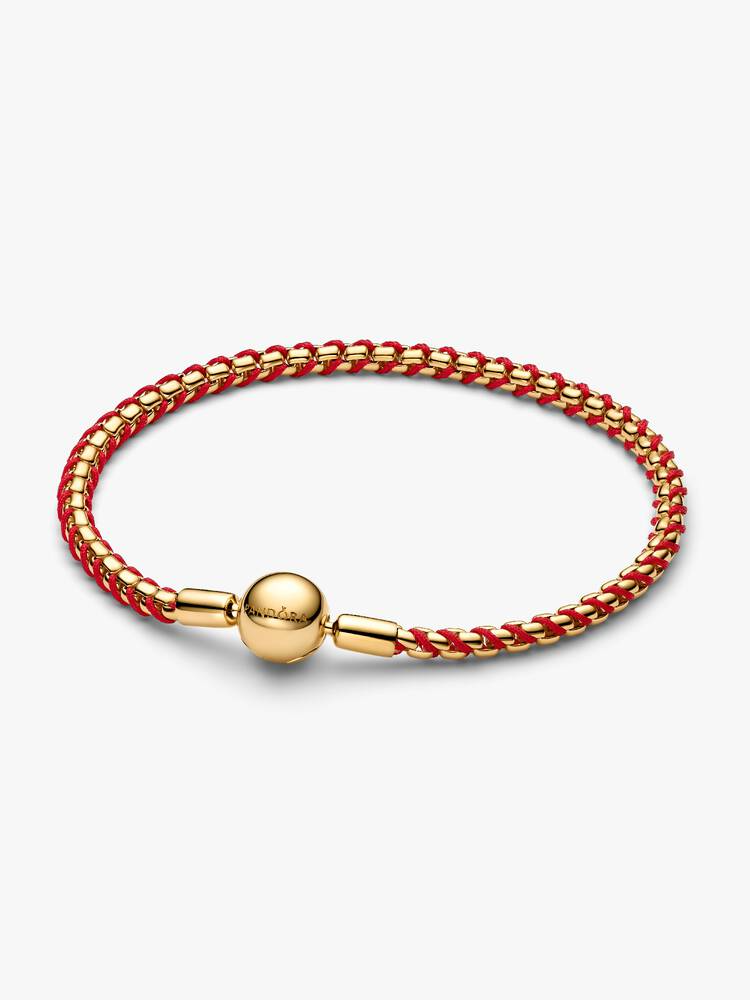 Opvallend contrast. Deze vergulde box chain-armband is doorweven met een rood textielkoord. We hebben het gevoel dat er binnenkort iets kleurrijks je stapel inglijdt ...

