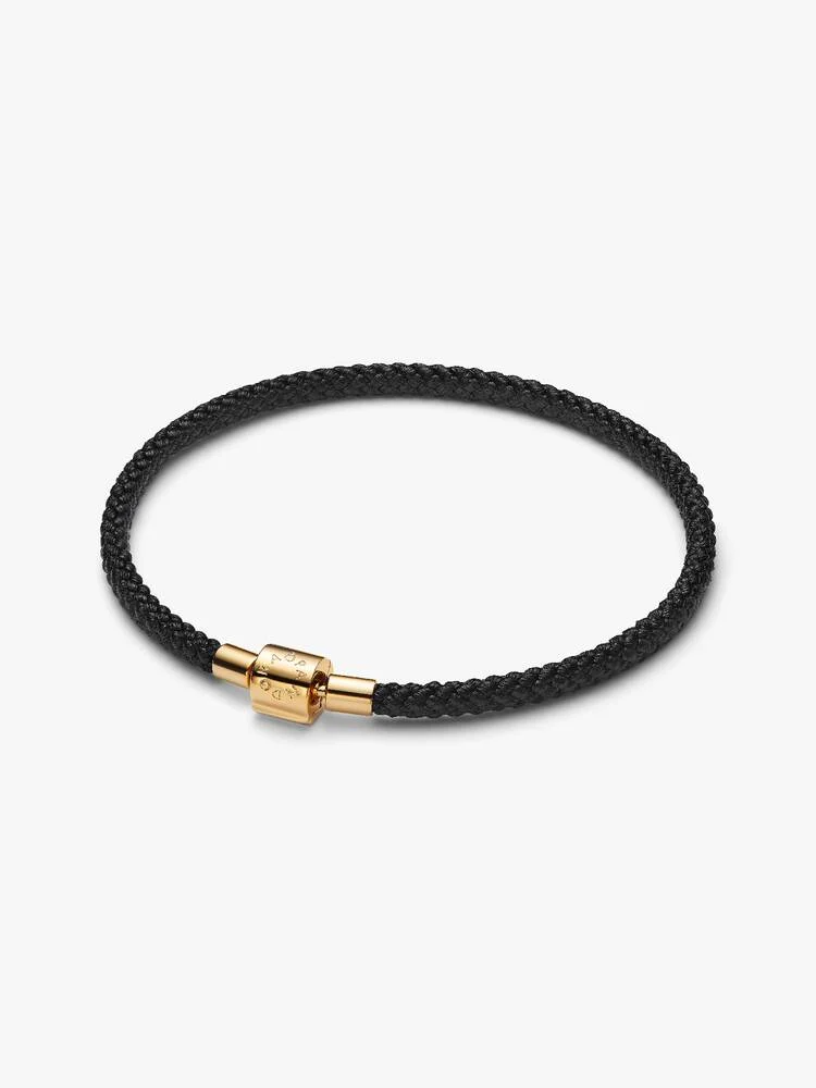 Cool, casual en eindeloos draagbaar. Deze armband is doorweven met een glanzend zwart koord en sluit met een vergulde sluiting. Style hem met of zonder bedels &ndash; de keuze is aan jou.

