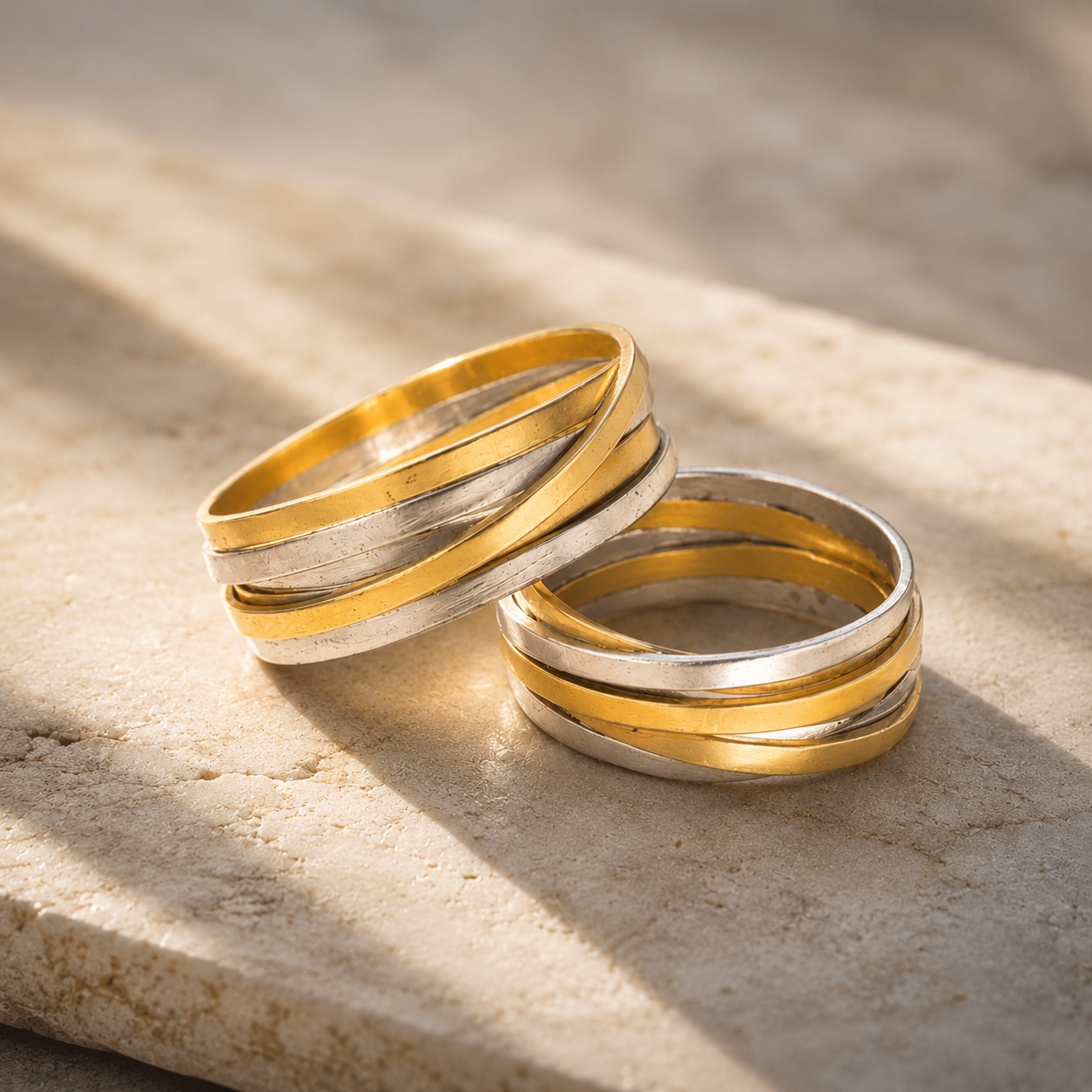 Zwei Ringe &ndash; so individuell wie ihre Tr&auml;ger
Diese au&szlig;ergew&ouml;hnlichen Unikat-Trauringe aus Gelb- und Wei&szlig;gold 750 leben vom spannenden Zusammenspiel zweier Goldfarben und einer bewusst freien Formensprache.
Mehrere Goldb&auml;nder scheinen sich spielerisch umeinander zu bewegen, kreuzen und &uuml;berlagern sich. Warmes Gelbgold trifft dabei auf k&uuml;hles Wei&szlig;gold und l&auml;sst ein lebendiges, immer wieder anders wirkendes Gesamtbild entstehen. Je nach Blickwinkel zeigt der Ring eine neue Facette.
Jeder Ring wird individuell von Hand gefertigt. Gerade die kleinen Unterschiede in Verlauf, Oberfl&auml;che und Anordnung der einzelnen Elemente verleihen dem Trauringpaar seinen unverwechselbaren Charakter. Es sind keine identischen Ringe &ndash; sondern zwei eigenst&auml;ndige Schmuckst&uuml;cke, die sichtbar zusammengeh&ouml;ren.
Ein besonderes Trauringpaar f&uuml;r Menschen, die Individualit&auml;t lieben und ihre Verbundenheit mit Schmuck ausdr&uuml;cken m&ouml;chten, der ebenso einzigartig ist wie ihre gemeinsame Geschichte.
Unikate aus Gelb- und Wei&szlig;gold 750 &ndash; handgefertigt im KISSNER Meisteratelier.
