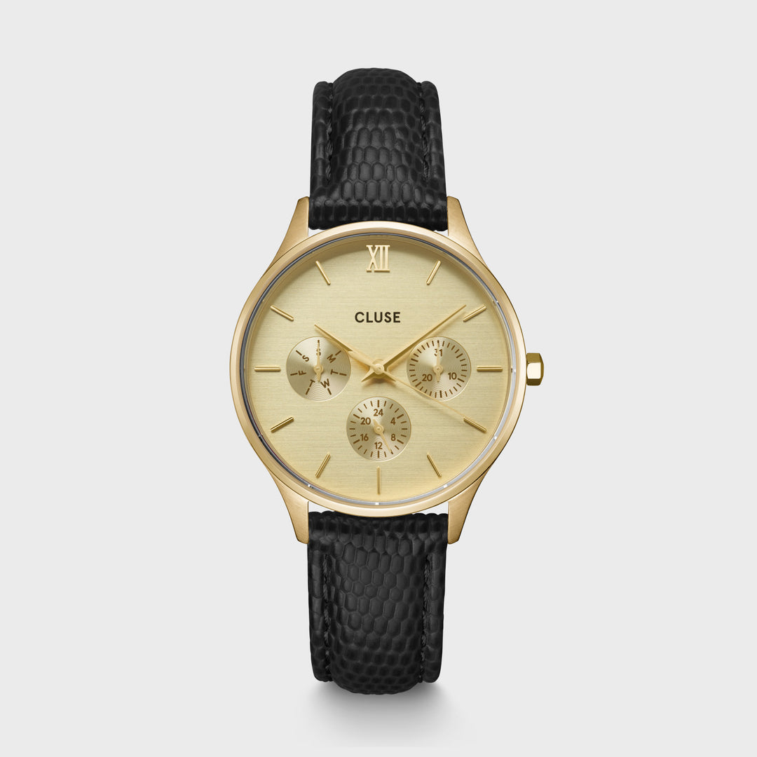 Het ronde Minuit Multifunction horloge voor dames heeft een 34 mm goudkleurige kast, goudkleurige wijzerplaat met 3 subwijzerplaten en een 16 mm zwart leren bandje met hagedisstructuur.
