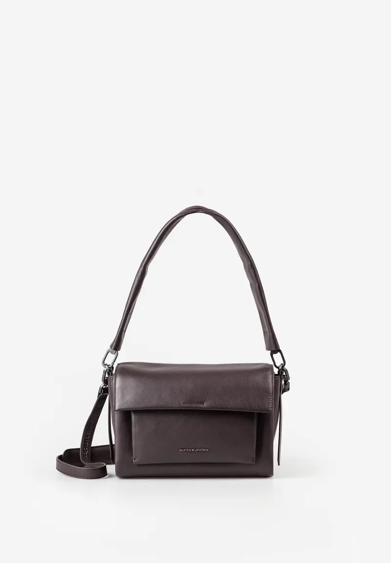 aunts & uncles NOON crossbody tas &ndash; Ground Coffee
De aunts & uncles NOON crossbody tas in de kleur Ground Coffee is een stijlvolle en veelzijdige leren schoudertas die functionaliteit combineert met een elegante uitstraling. Deze compacte crossbody tas is de kleinere variant van de Breeze en is ideaal voor dagelijks gebruik, een dagje in de stad, op reis of onderweg naar kantoor.
De NOON is gemaakt van zacht leer en heeft een vormvaste, maar soepel aanvoelende constructie. De zachte lijnen geven de tas een tijdloze uitstraling, terwijl de slimme indeling ervoor zorgt dat je je essentials overzichtelijk kunt meenemen.

Onder de overslag met praktische magneetsluiting bevindt zich een voorvak. Het hoofdvak sluit met een rits en biedt voldoende ruimte voor je dagelijkse benodigdheden. Binnenin vind je een extra ritsvak, een groot steekvak dat bijvoorbeeld geschikt is voor je smartphone en een handig kaartvak. Een sleutelband houdt je sleutels gemakkelijk binnen handbereik. Daarnaast wordt de tas geleverd met een uitneembaar extra tasje voor nog meer flexibiliteit.

De NOON beschikt over een afneembare en verstelbare leren schouderband met extra schouderpadding. Dankzij de extra korte schouderband, eveneens afneembaar, kun je de tas op verschillende manieren dragen.

De hoogwaardige hardware, ovale mat geborstelde details in Smokey Grey en het subtiele metalen logo geven de tas een verfijnde uitstraling. De lichte voering met bloemenmotief maakt het interieur compleet. Voor het netjes opbergen van de tas wordt een praktische stofzak meegeleverd.

Kenmerken aunts & uncles NOON
Gemaakt van zacht leer
Kleur: Ground Coffee
Hoofdvak met ritssluiting
Overslag met magneetsluiting
Opgezet voorvak onder de overslag
Ritsvak aan de achterzijde met extra beveiliging
Ritsvak aan de binnenzijde
Kaartvak
Groot steekvak, bijvoorbeeld voor een smartphone
Handige sleutelband
Uitneembaar extra tasje
Afneembare en verstelbare leren schouderband
Schouderband met extra padding
Korte, afneembare schouderband van twee lagen leer
Hoogwaardige hardware
Ovaal, mat geborsteld beslag in Smokey Grey
Subtiel metalen logo
Lichte, floral gedessineerde voering
Inclusief stofzak
Onderdeel van de Bohemian Vibes collectie
Gewicht: ca. 620 gram
Afmetingen: ca. 26 x 12,5 x 18 cm (L x D x H)
Leren crossbody tas voor iedere dag
De aunts & uncles NOON is een ideale keuze voor wie een leren crossbody tas voor dames zoekt met een praktische indeling en meerdere draagmogelijkheden. Het ruime hoofdvak, de verschillende rits- en steekvakken en het extra tasje bieden volop ruimte voor je dagelijkse essentials. De warme Ground Coffee kleur en hoogwaardige leren afwerking maken deze schoudertas een stijlvolle toevoeging aan iedere outfit.
