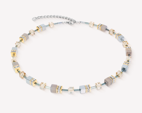 De GeoCUBE&reg; Necklace Agate & Hematite grijs-goud combineert zachte grijstinten met warme gouden accenten in een verfijnde kleurencompositie die tijdloze elegantie uitstraalt. Kenmerkende GeoCUBE-elementen&reg;, glinsterende agaat, fonkelende Swarovski-kristallen&reg; en schitterende kristallen rondellen zorgen voor verfijnde lichtreflecties en voegen diepte toe aan het ontwerp. Deze premium designer ketting past bij zakelijke kleding, alledaagse styling en elegante avondlooks met moeiteloze veelzijdigheid, terwijl het tweekleurige palet prachtig past bij zowel zilver- als goudkleurige sieraden. De harmonieuze wisselwerking van matte en gepolijste oppervlakken zorgt voor een evenwichtige uitstraling vol subtiele schittering. Zorgvuldig geco&ouml;rdineerde kleuren en iconische kubuselementen geven de ketting haar kenmerkende karakter en zorgen voor uitzonderlijke veelzijdigheid. Gedragen op zichzelf of samen met de bijpassende druppeloorbellen en armband, vormt het een elegante sieradenset die de onmiskenbare ontwerpfilosofie van COEUR DE LION weerspiegelt. Agaat, zilver- en goudkleurige hematiet, Swarovski-kristallen&reg;, kristallen rondellen, hoogvarig roestvrij staal en goudkleurig roestvrij staal combineren premium materialen met uitzonderlijk vakmanschap.