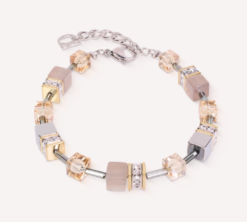 De GeoCUBE&reg; Armband Agate & Hematiet grijs-goud combineert zachte grijze tinten met warme gouden accenten in een prachtig uitgebalanceerd kleurenpalet dat zowel modern als tijdloos aanvoelt. Glinsterende agaat, kenmerkende GeoCUBE-elementen&reg;, fonkelende Swarovski-kristallen&reg; en kristallen rondellen zorgen voor subtiele schittering die bij elke beweging het licht vangt. Deze premium designerarmband voegt een elegante finishing touch toe aan zowel dagelijkse styling als speciale gelegenheden. De verfijnde tweekleurige uitstraling maakt het gemakkelijk te combineren met zowel zilver- als goudkleurige sieraden, wat uitzonderlijke veelzijdigheid biedt. Gedragen op zichzelf of samen met de bijpassende ketting en druppeloorbellen, cre&euml;ert het een geco&ouml;rdineerde sieradenset die de onmiskenbare stijl van COEUR DE LION weerspiegelt. Agaat, zilver- en goudkleurige hematiet, Swarovski-kristallen&reg;, kristallen rondellen, hoogvarig roestvrij staal en goudkleurig roestvrij staal combineren premium materialen met uitzonderlijk vakmanschap.