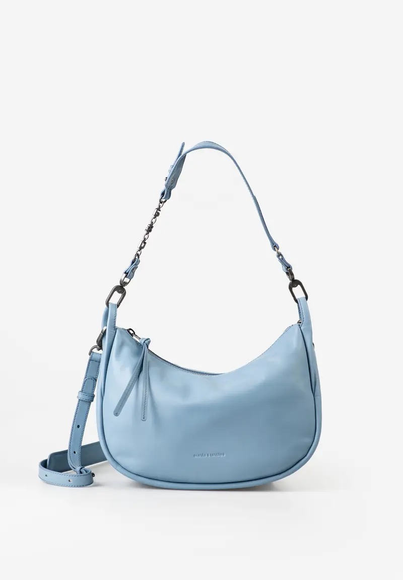 Raven &ndash; stijlvolle halfmoon schoudertas
De Raven is een ruime halfmoon bag met een elegante, gebogen vorm en een moderne uitstraling. Het zachte, hoogwaardige leer voelt comfortabel aan en de brede schouderband met subtiel a&u-ket&shy;tingdetail geeft de tas een bijzondere touch. Dankzij de extra draagband is Raven ook als crossbody te dragen.
Hoofdvak met ritssluiting
Achtervak en twee binnenvakken met rits
Sleutelkoord en uitneembaar extra etui
Brede schouderband met a&u-metalen kettingdetail
Afneembare, verstelbare en gevoerde leren crossbodyband
Stevige bodem voor extra vormbehoud
Hoogwaardige metalen details in smokey grey
Licht, bloemrijk gevoerd
Inclusief stofzak
Kleur: blue shadow
Afmetingen: ca. 30 &times; 10 &times; 18,5 cm
Gewicht: 460 g