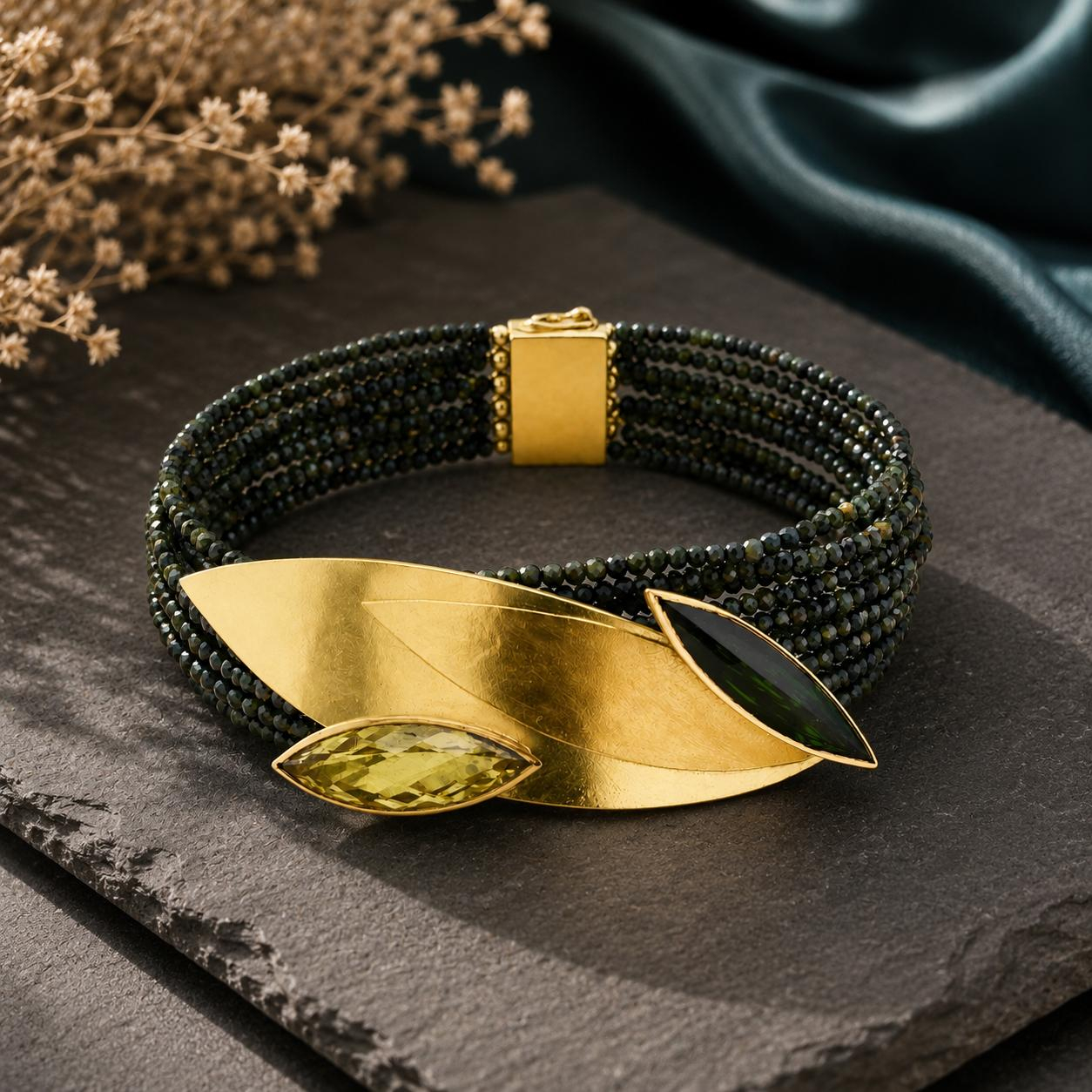 Turmalinarmband 12-reihig mit elegant-floral gestaltetem Schmuckteil in Feingold und Gold 750, einem Turmalin- und Lemmocitrinnavette. L&auml;nge 19cm

UNIKAT

gefertigt im KISSNER Meisteratelier
Design: Carsten Kissner