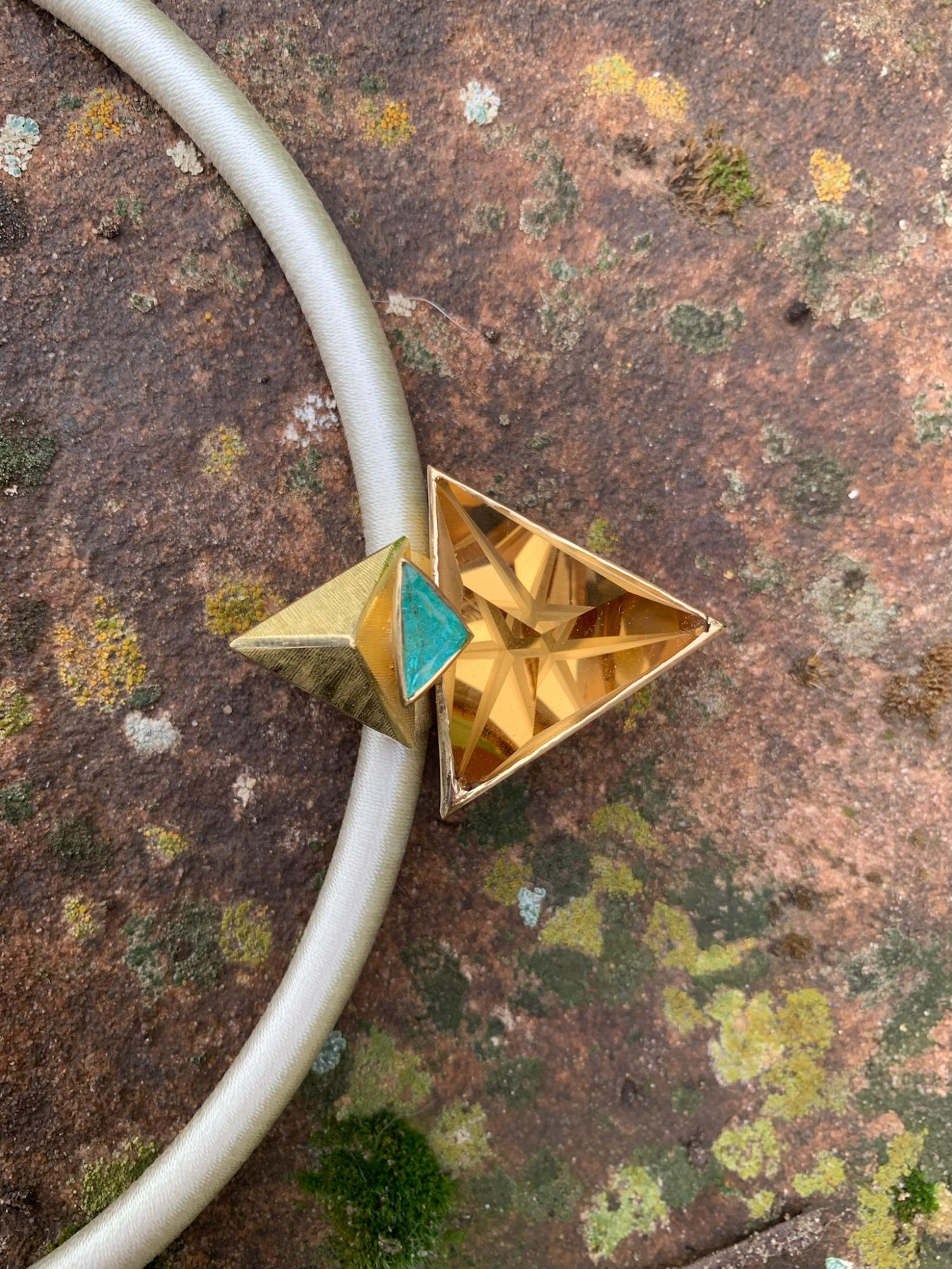 Anh&auml;nger gefertig in Gelbgold 750/ooo, mit einem Citrin 32,98ct und einem Paraiba Turmalin  1,10ct.
Die Aufh&auml;ngung ist R&uuml;ckseitig in das Schmuckst&uuml;ck integriert, mit einem Durchlass von 8 mm.

L&auml;nge 4,5 cm
Breite 3 cm