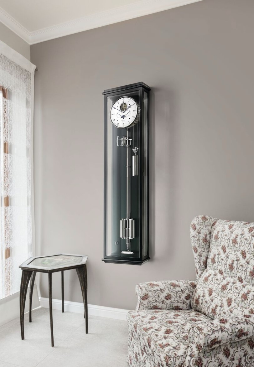 De Classica Secunda Lunaris in zwarte slijplak kast combineert klassiek horlogemakersvakmanschap met een uitzonderlijke, handgeschilderde maanfase-aanduiding. Op de elegant verzilverde wijzerplaat vormen de tijd, kleine seconden, datum, dag van de week en maanfase-indicator een harmonieus, tijdloos elegant geheel. De mysterieuze aard van de maan is het bepalende designelement van deze buitengewone, nauwkeurige slingerklok.