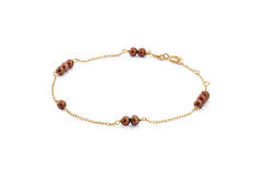 Deze Jackie armband, is een elegante armband van 14k goud met bruine parels. Deze tijdloze armband valt onder de categorie sieraden, specifiek ontworpen als een subtiele en verfijnde toevoeging aan elke outfit. Draag hem los om een pols voor een chique uitstraling, of combineer met andere sieraden voor een gelaagd effect.

Wees voorzichtig met parfum en bodylotion, want parels zijn kwetsbaar