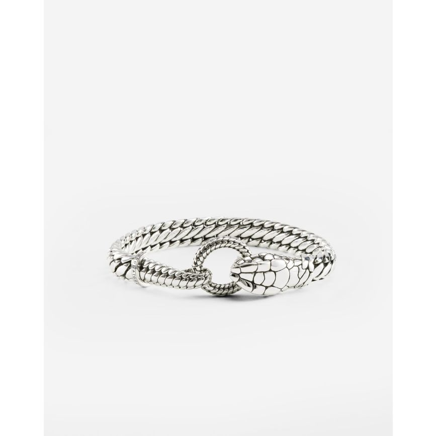 De Armband Ben XS Slang Zilver weerspiegelt de symboliek van de slang &ndash; een teken van vernieuwing, hoop en bescherming. De Ben-structuur die de huid van een slang voorstelt, gaat naadloos over in een gedetailleerde slangenkop en staart die samenkomen bij de clipsluiting op de pols. Dit krachtige ontwerp herinnert aan de oneindige cyclus van groei en transformatie, een talisman van innerlijke kracht en bescherming. Ontworpen in Amsterdam en handgemaakt in Zuid-Oost Azi&euml; van 100% gerecycled 925 sterling zilver. De maat is E+.