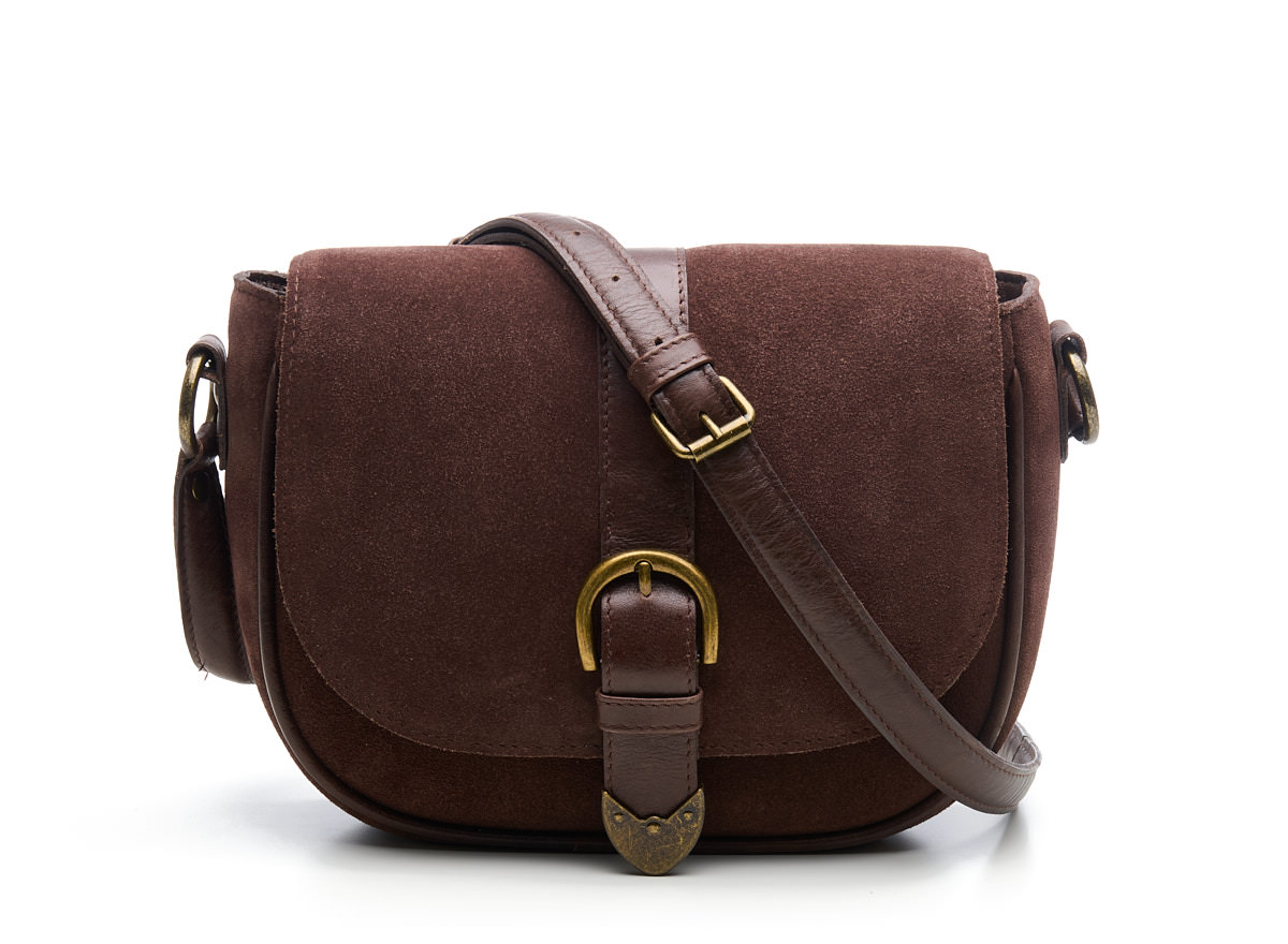 Afmeting  25 x 17 x 7 cm

Suede Crossbody/Schoulderbag met leren details en opvallende buckle voorop.
De Saddle Darwin is d&eacute; perfecte mix van elegantie en functionaliteit. Deze stijlvolle saddle bag is uitgevoerd in zacht suede met een luxe leren afwerking rond de randen en leren band over de tas met een antic Brass buckle en antic brass uiteinde wat zorgt voor een chique en tijdloze uitstraling. Ideaal voor wie houdt van een opvallende, maar verfijnde tas.


De tas sluit met een overslagflap met magneetsluiting en heeft daaronder een extra rits, zodat je spullen altijd veilig opgeborgen zijn. Aan de achterkant vind je nog een handig ritsvak voor items die je snel wilt pakken.

Binnenin is de tas verrassend ruim en praktisch ingedeeld. Onder de rits vind je een ruim vak met daarnaast extra zijvakken: een ritsvak en een insteekvak, perfect voor het overzichtelijk opbergen van je essentials zoals telefoon, portemonnee en sleutels.
Dankzij de lange, verstelbare band draag je de tas comfortabel crossbody. Liever een meer elegante look? Gebruik dan de bredere, korte schouderband voor een stijlvolle uitstraling.
Waarom kiezen voor de Saddle Darwin?
Gemaakt van zacht suede met luxe leren afwerking
Overslagflap met magneetsluiting en extra ritssluiting
Handig ritsvak aan de achterzijde

Lange verstelbare crossbody band
Brede, korte schouderband voor een trendy look
Stijlvol, praktisch en veelzijdig
Ideaal voor:
Dagelijks gebruik, werk, een avondje uit of een dagje shoppen